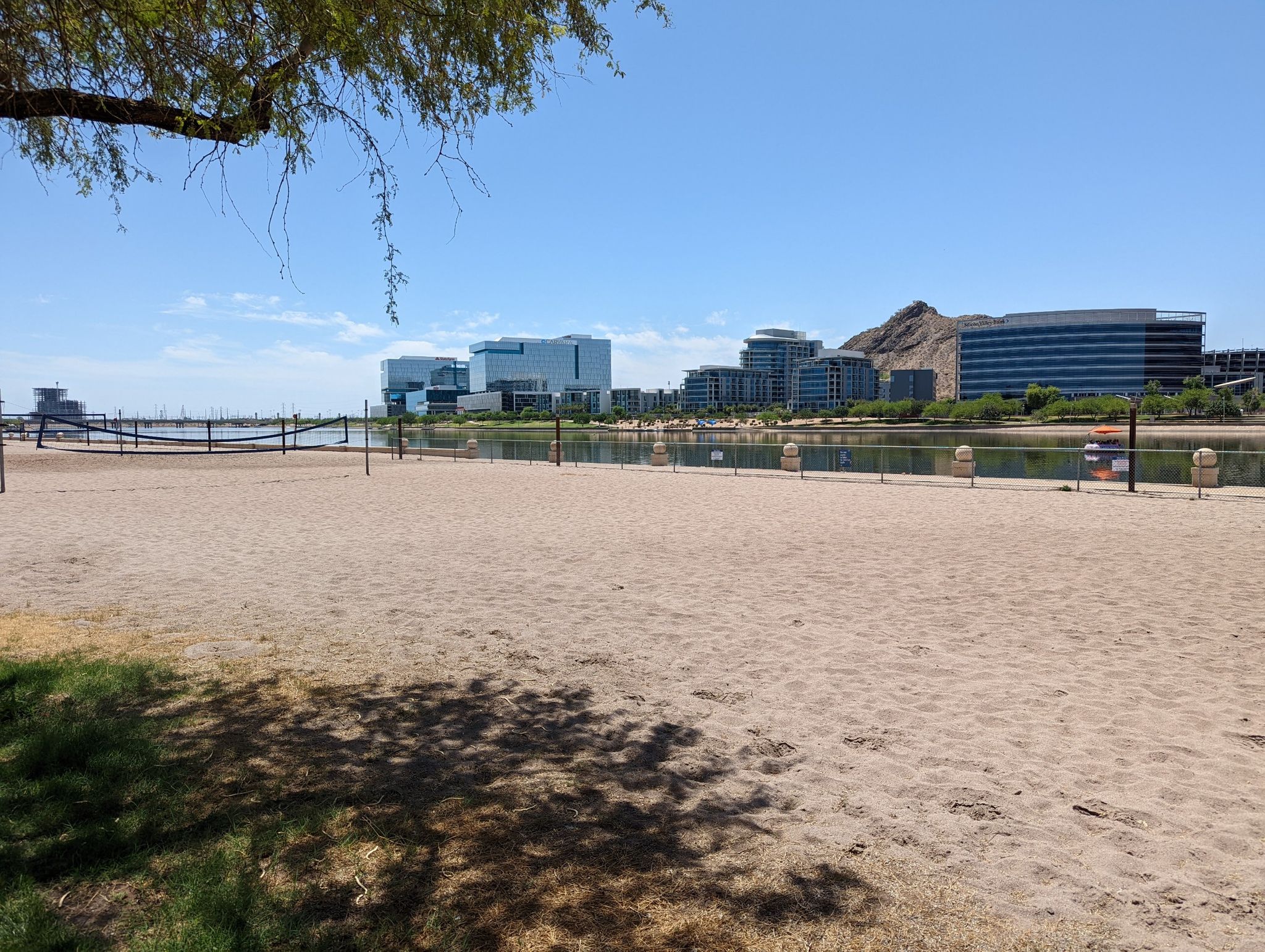 Sunny sandy beach with distant city buildings and a mountain across water. - Canal, Lizard and Loma Trail