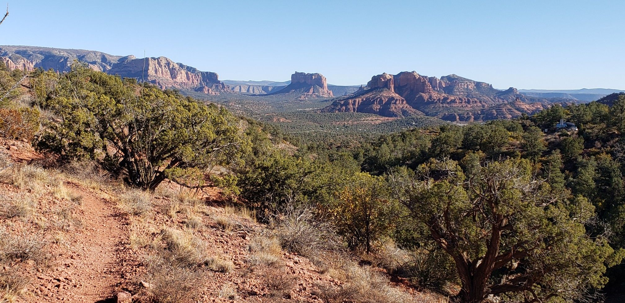 Panoramic view of a green valley and distant red rock mountains under clear skies. - Skywalker, Old Post, and Herkenham Loop