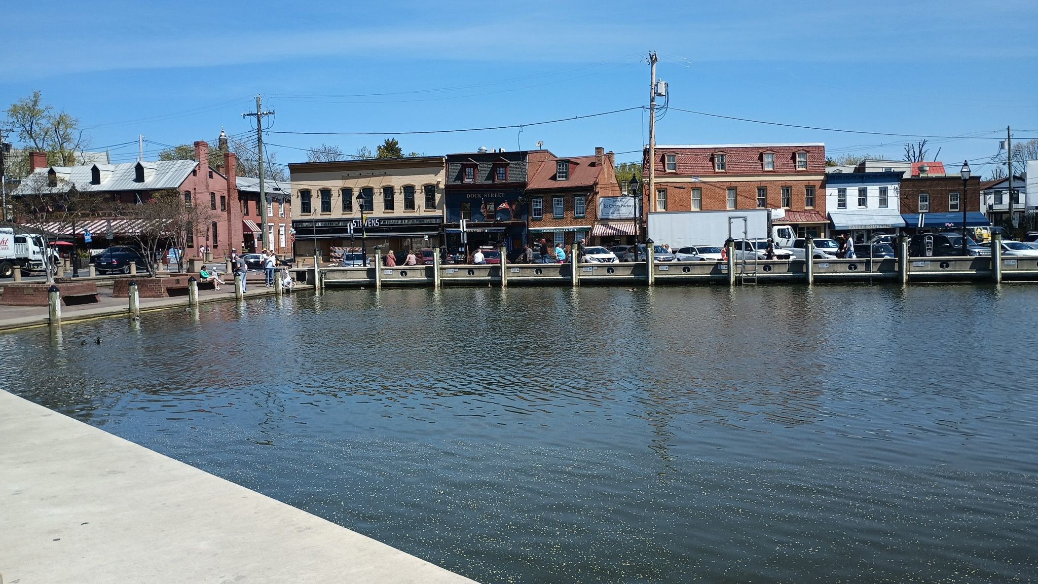 Historic brick buildings line a waterfront under a clear blue sky. - Baltimore & Annapolis and BWI Trail Loop
