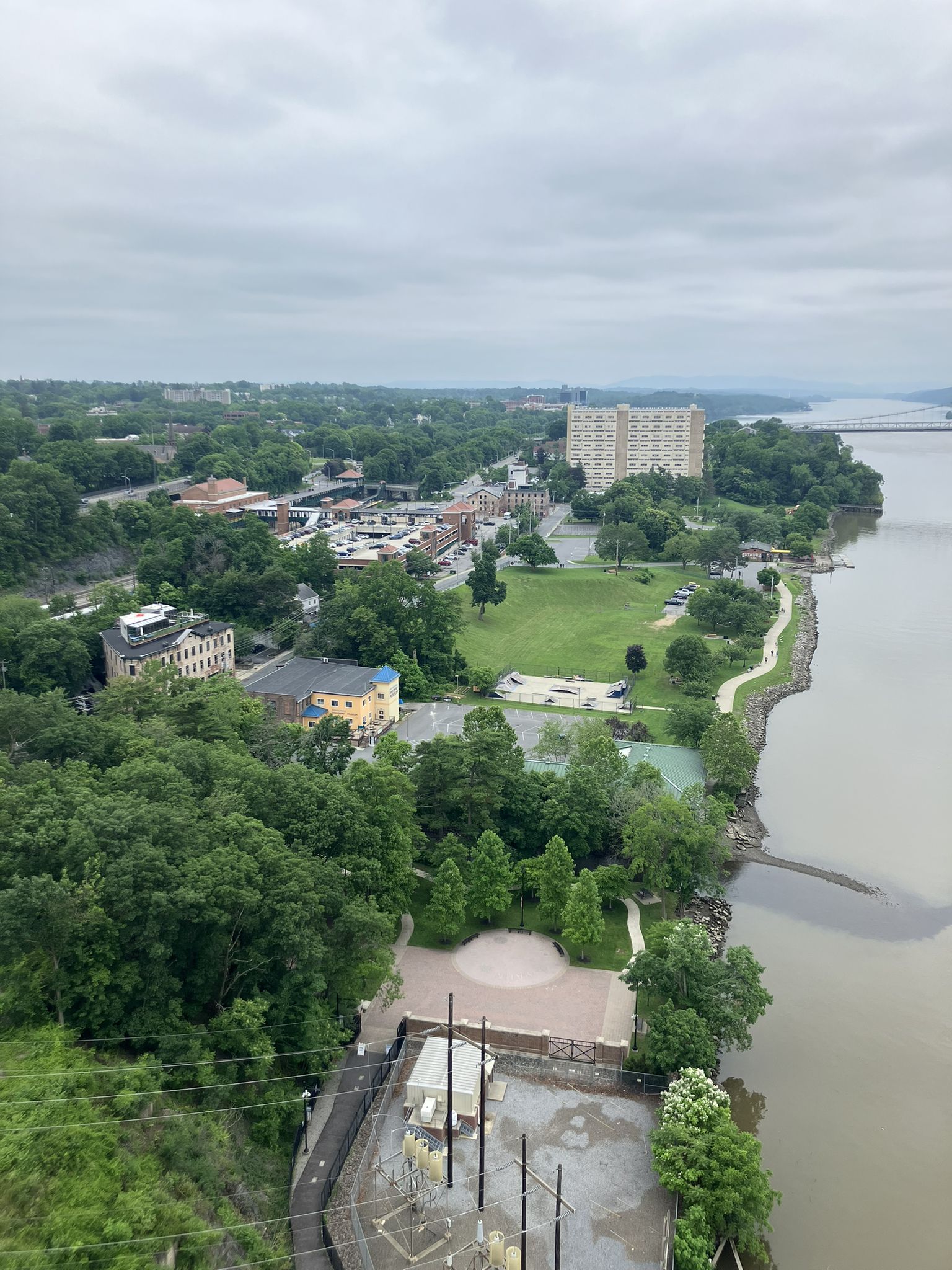 Aerial view of a town, park, and river under an overcast sky. - Dutchess Rail Trail and Pleasant Valley Loop