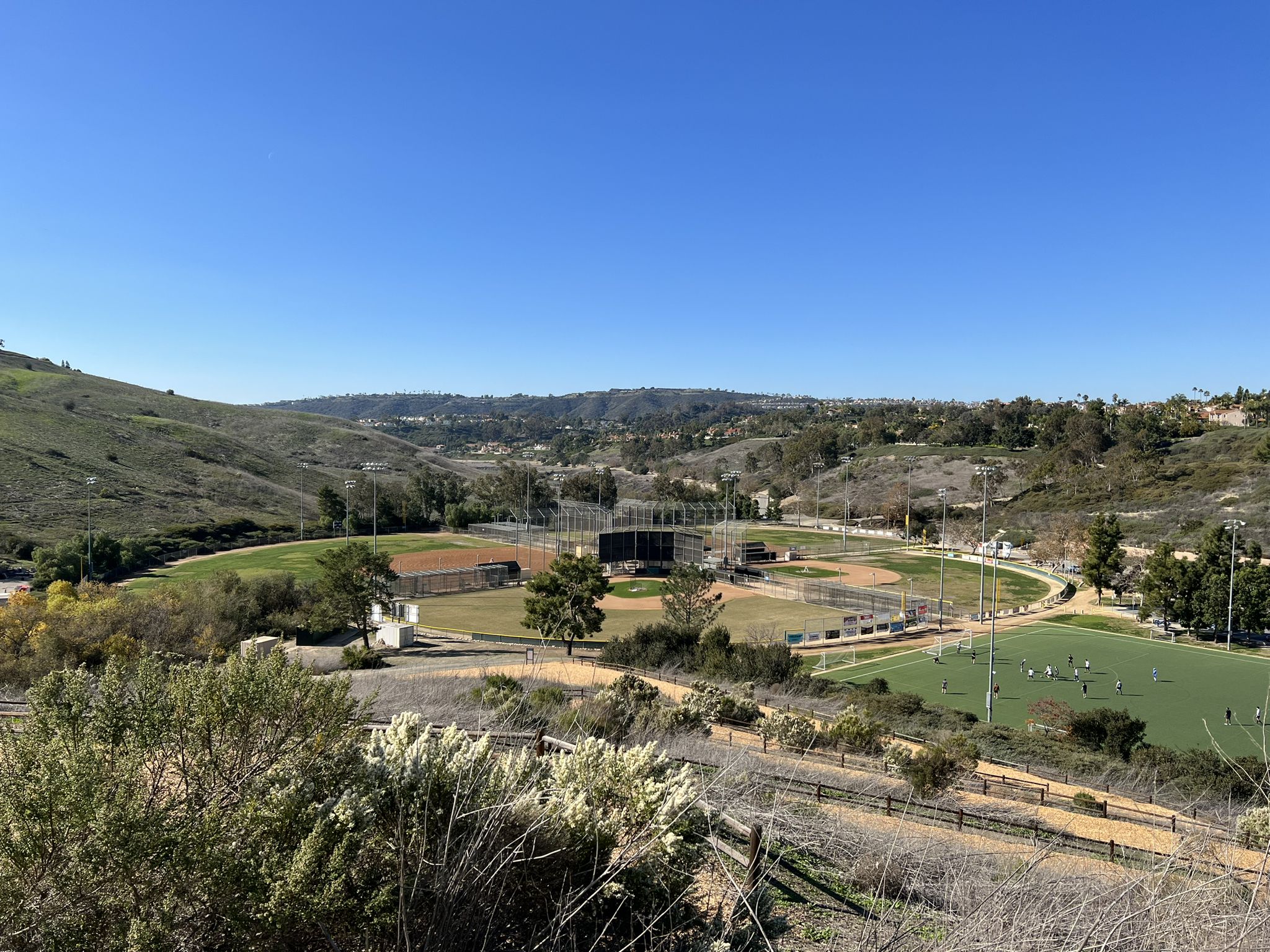 Sunny valley with multiple sports fields and distant green hills. - San Juan Creek and Salt Creek Trail Loop