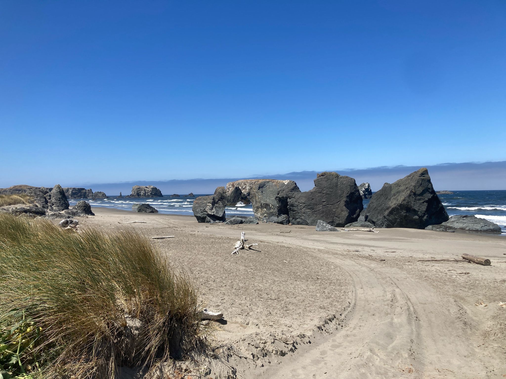 Bright sandy beach with large rock formations, an arch, and ocean. - Bandon loop — Oregon Coast