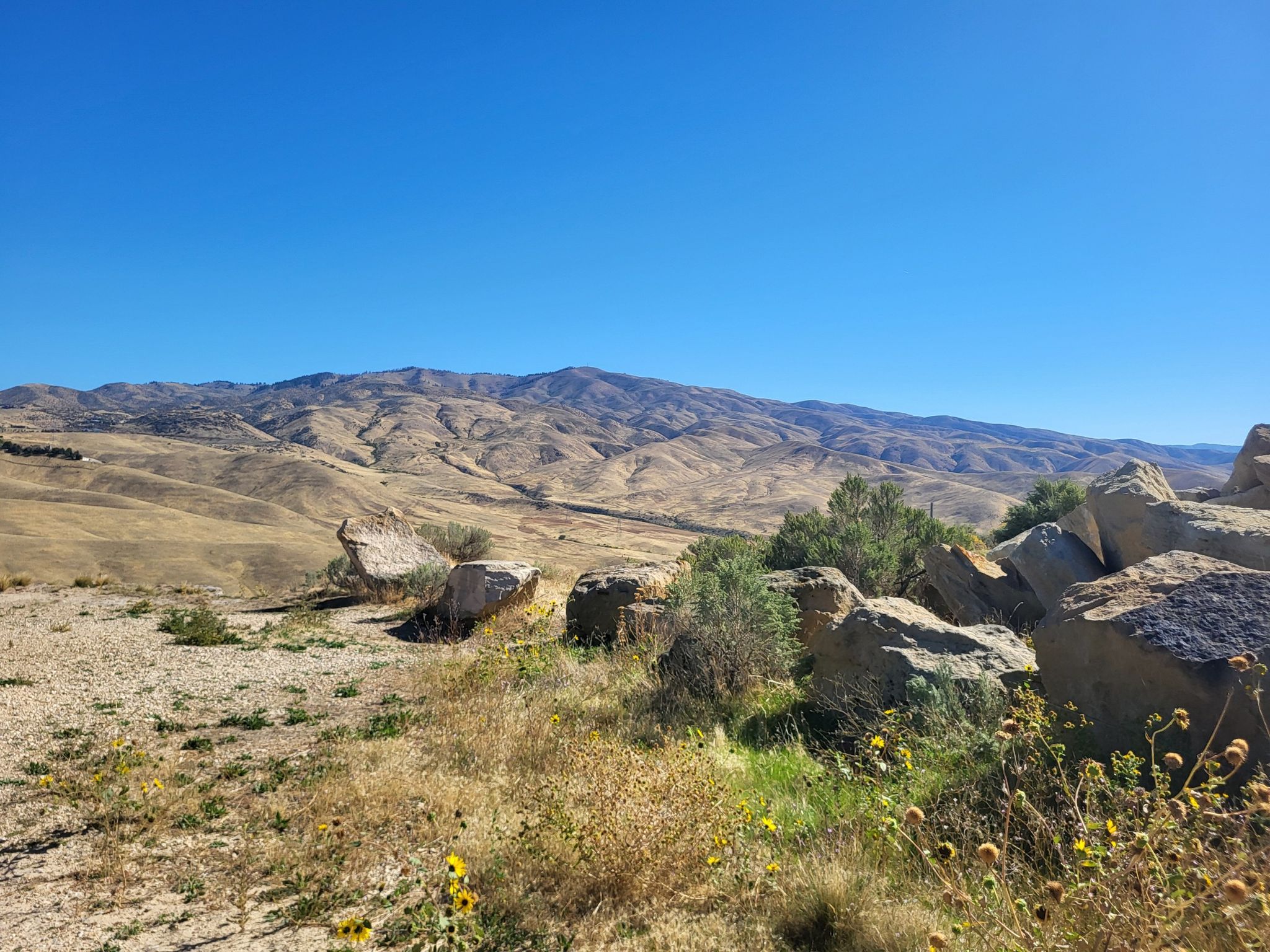 Arid hills and distant mountains under a clear blue sky. - Table Rock Quarry Loop