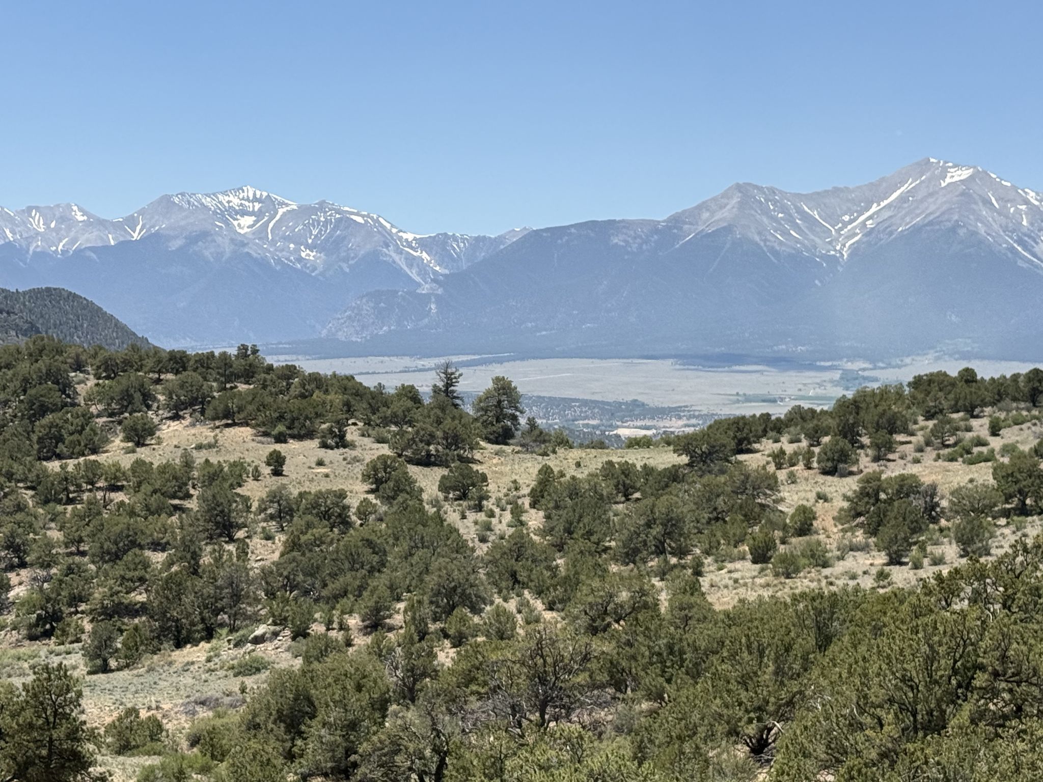 Rolling arid hills covered in sparse trees, with distant snow-capped mountains. - Midland Bike Trail & OHV Roads loop