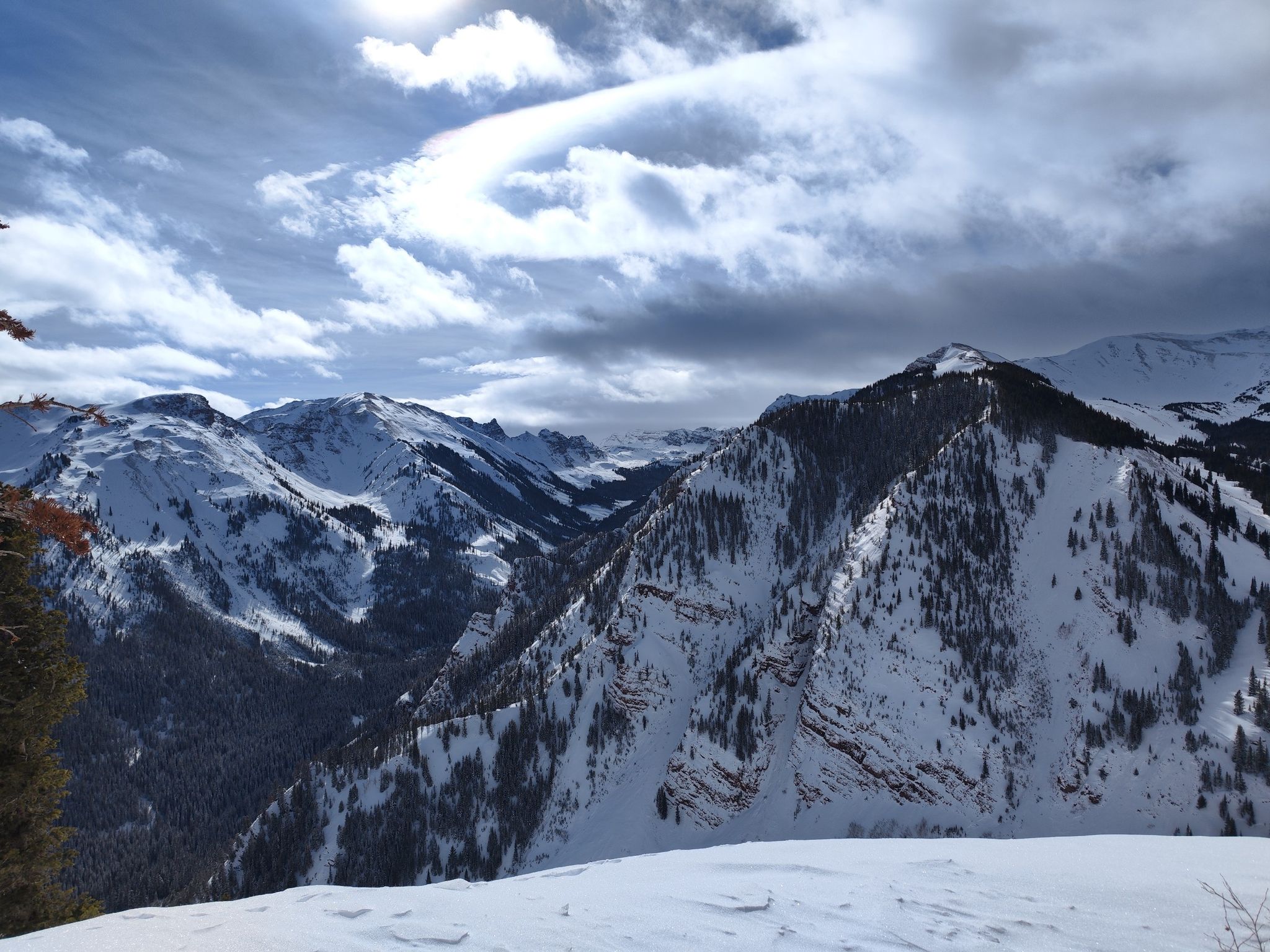 Snow-covered mountains and valleys under a cloudy sky with bright sun. - Cattle Creek loop — Gravel