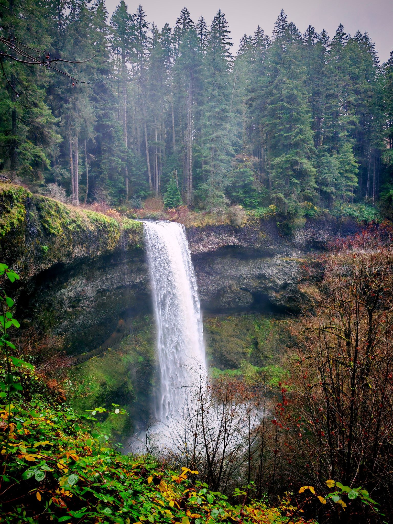 Tall waterfall plunging over a dark cliff into a pool, surrounded by autumn foliage. - Perimeter, Rackett Ridge, and Rim Trail Loop