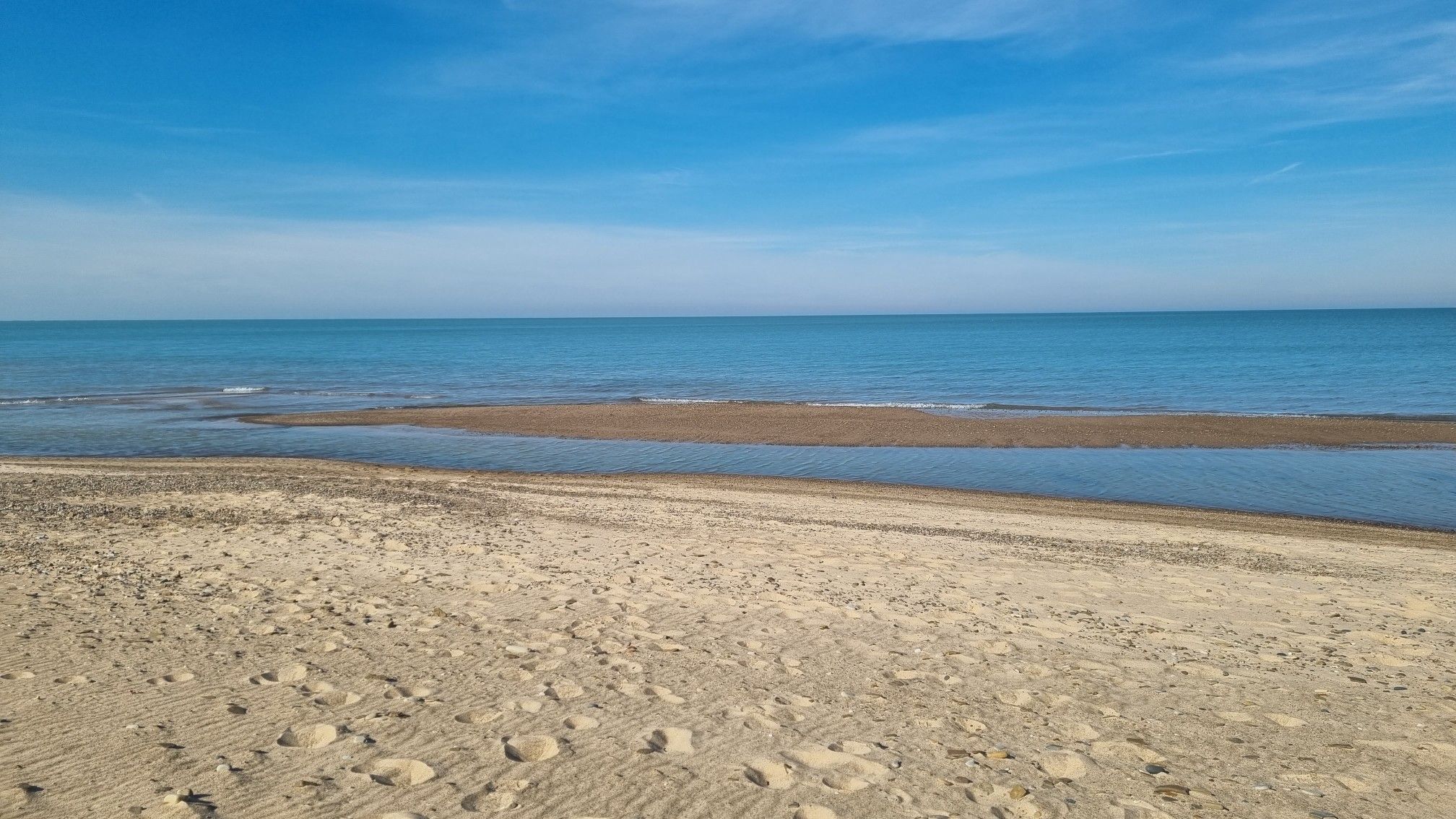 Expansive sandy beach with shallow water and distant blue ocean under a clear sky. - View of Lake Michigan beach – Lake Michigan Beach loop from Gleason Heights