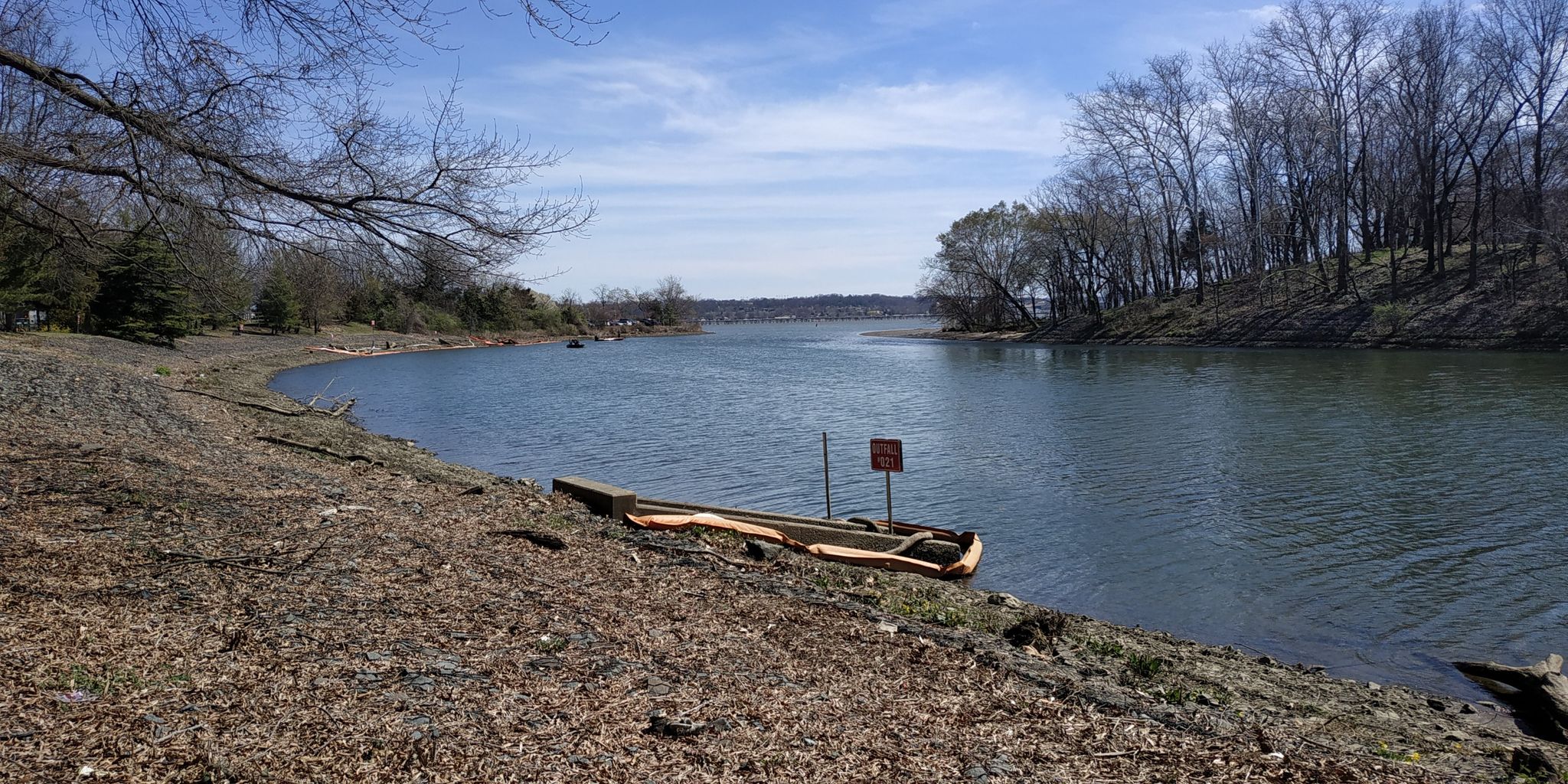 Small boat on a rocky riverbank, with bare trees and a wide river. - Alexandria City Marina – Mount Vernon Trail loop from Bailey's Crossroads
