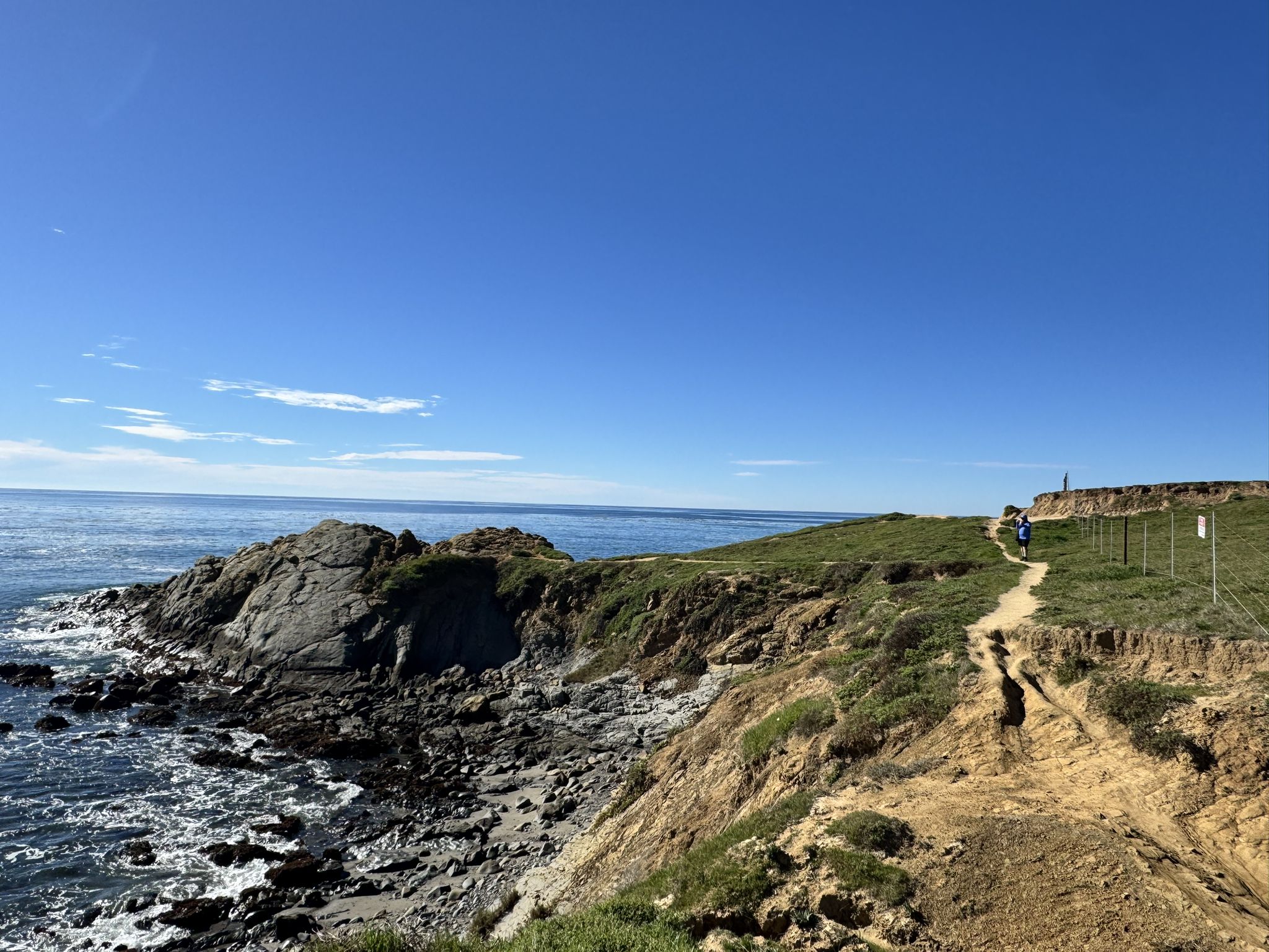 Coastal trail on a grassy cliff overlooking the ocean under a clear blue sky. - Harmony Headlands State Park loop from Harmony Headlands State Park