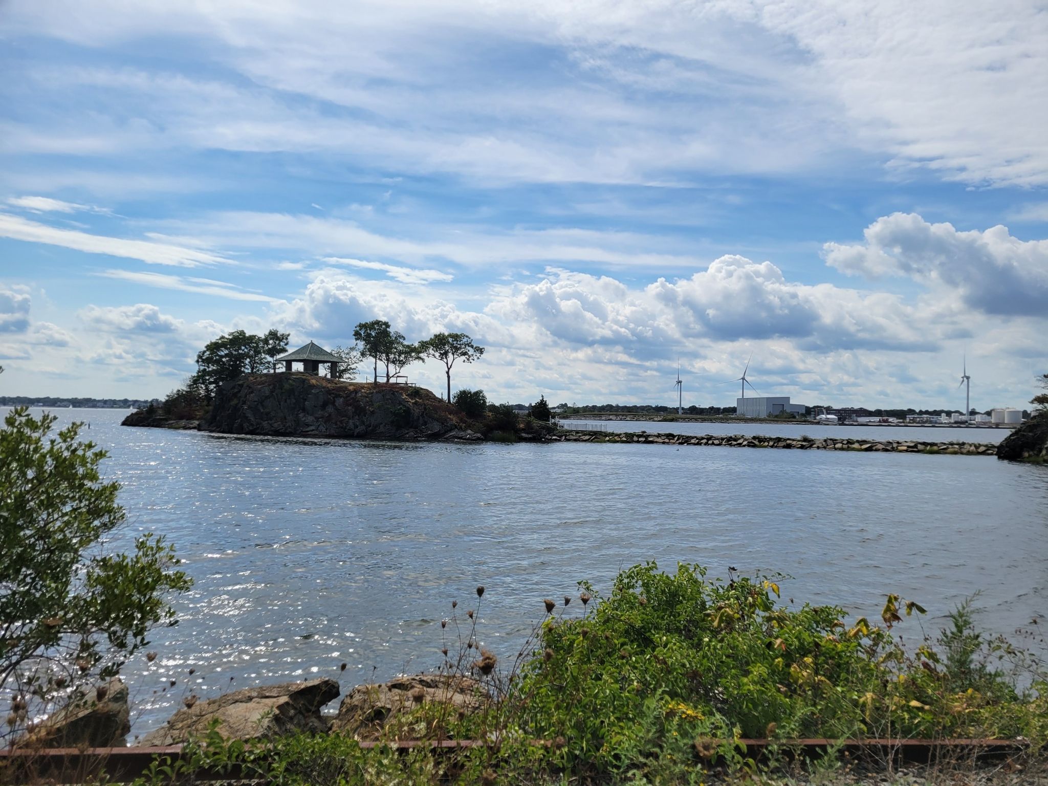 A small island with a gazebo and trees in a bay, industrial background. - India Point Park – East Bay Bike Path loop from Gilbert Marsh