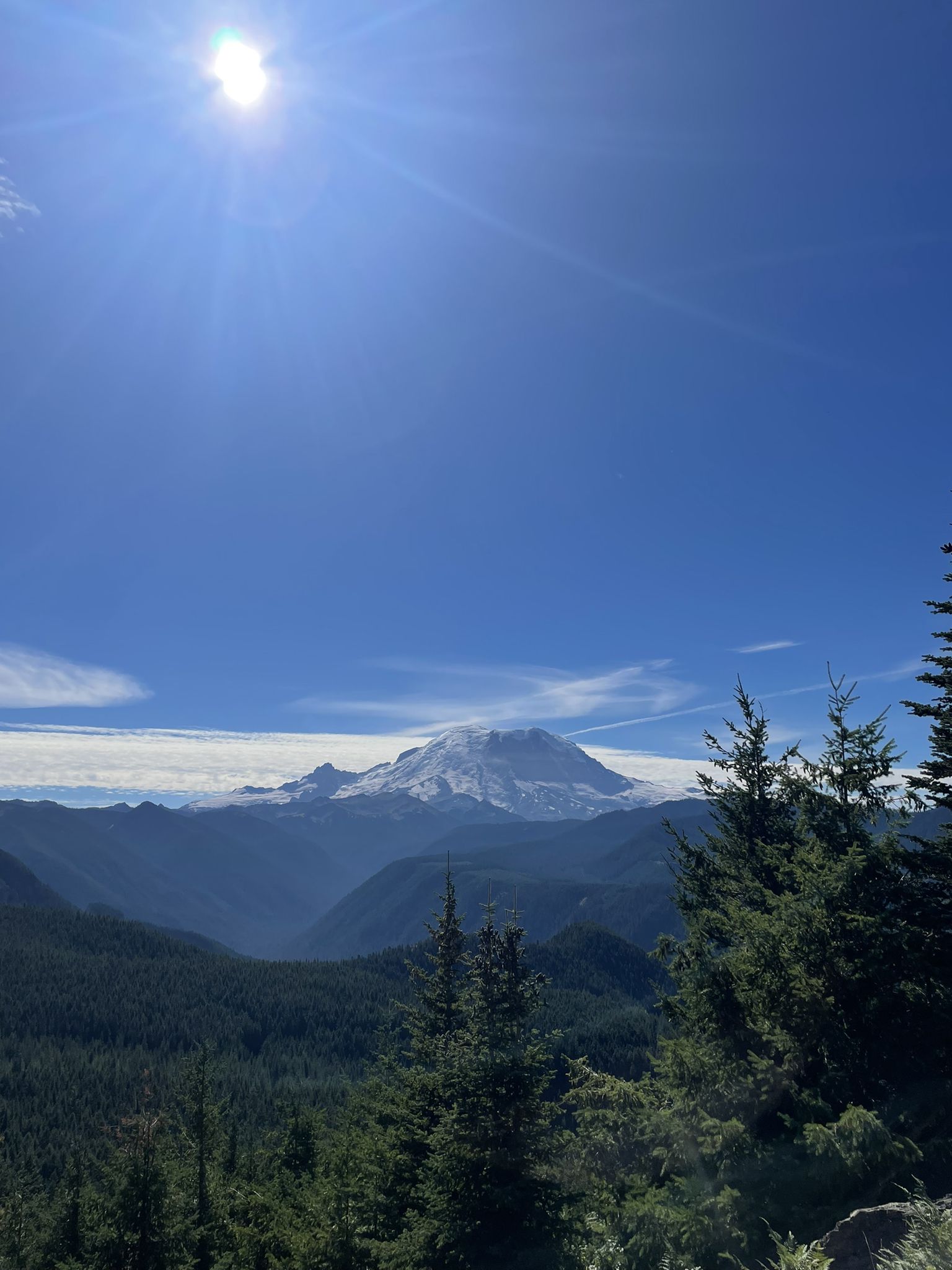 Bright sun over a snow-capped mountain, forested valleys, and clear blue sky. - Forest Road 7315 – Suntop Lookout loop from Ranger Creek Trailhead