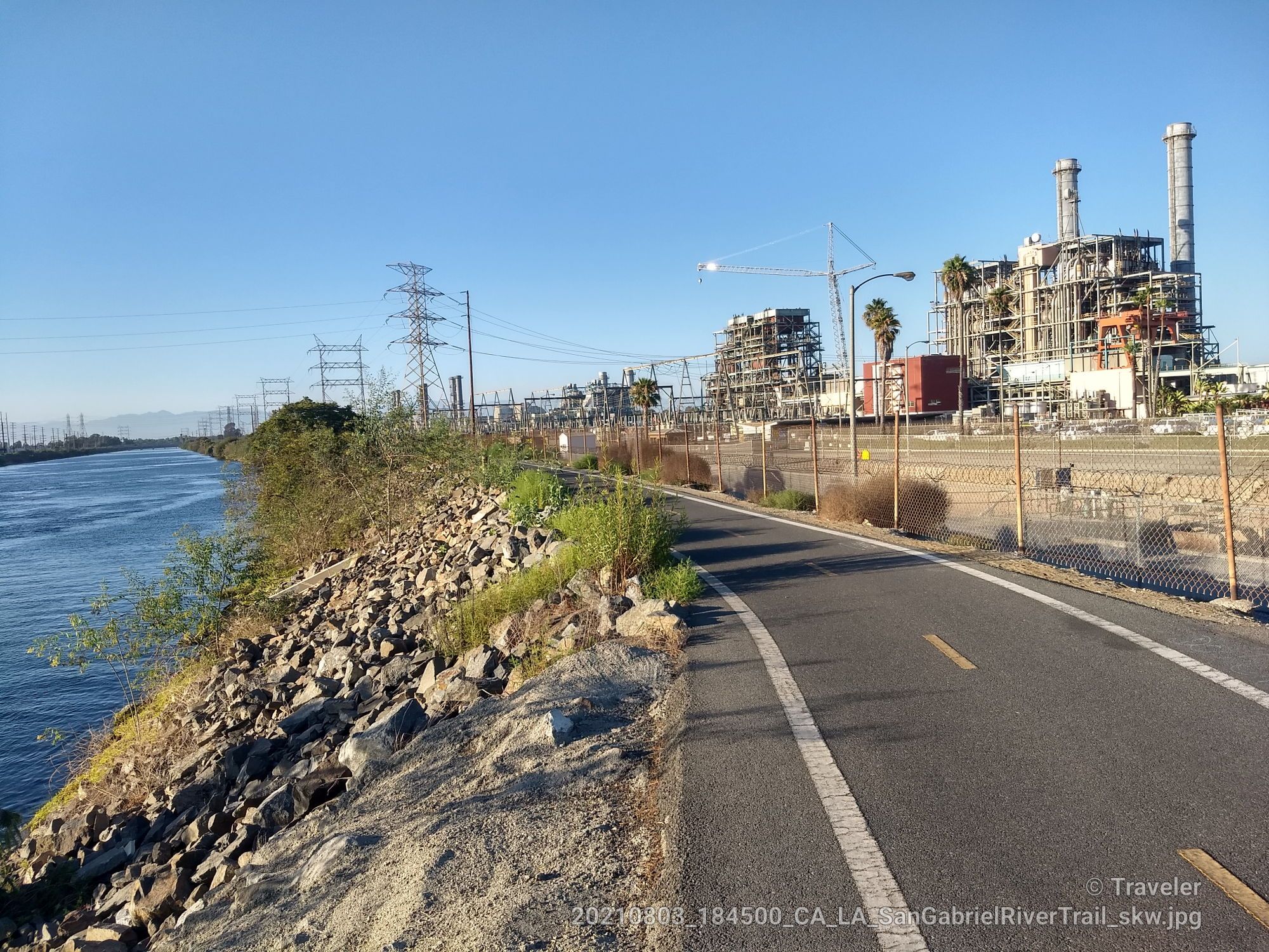 Paved path beside a river, with power lines and large industrial buildings. - San Gabriel River Trail – San Gabriel River Trail loop from Seal Beach National Wildlife Refuge