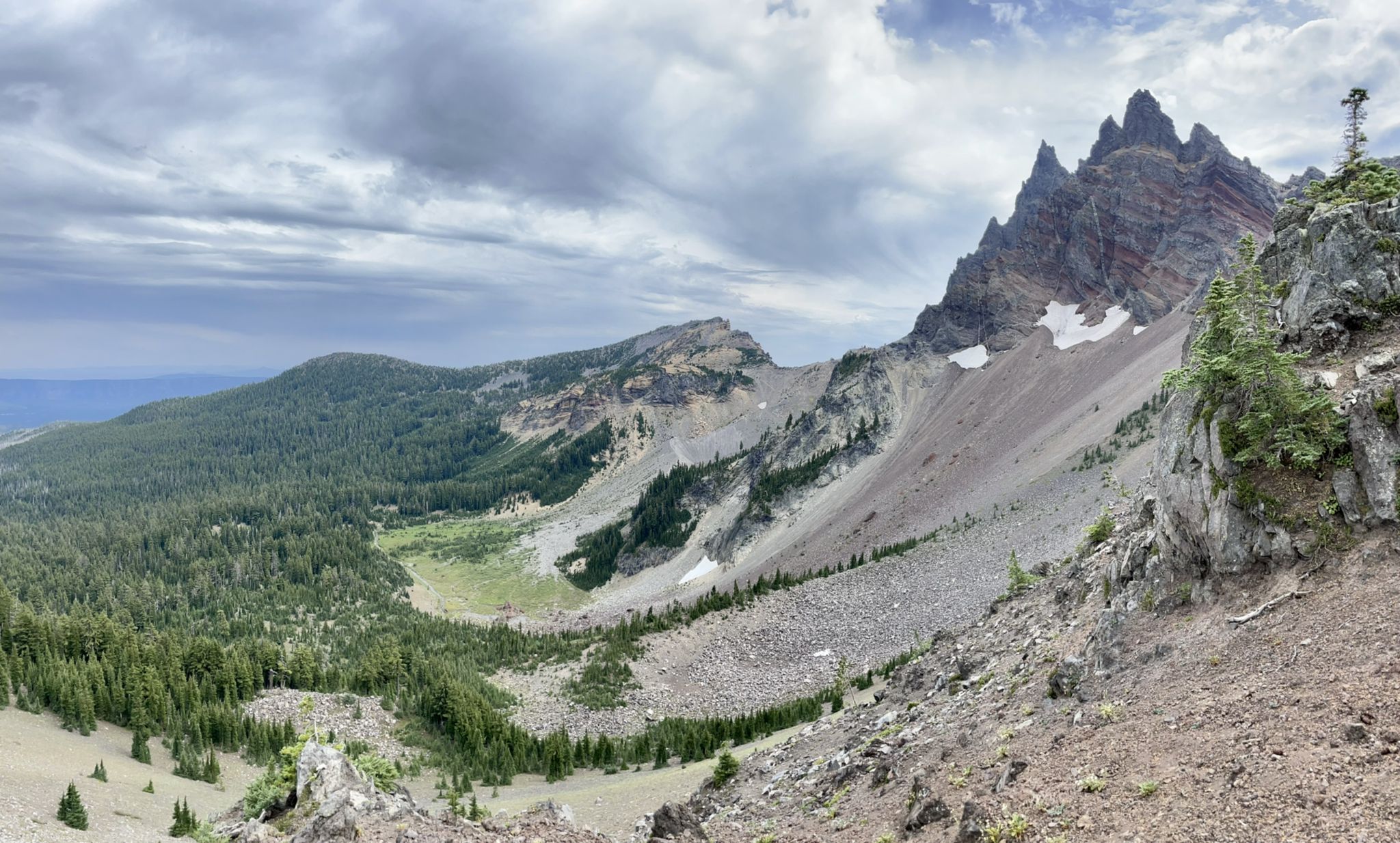 A dramatic mountain valley with jagged peaks, forested slopes, and cloudy skies. - PCT: OR Section F - Highway 242 to Highway 35 (Barlow Pass)