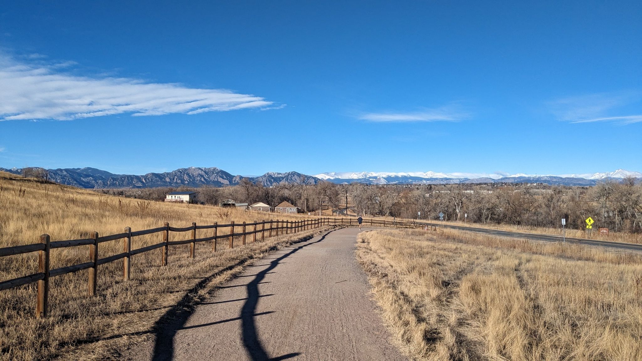 A gravel path next to a wooden fence, leading towards distant mountains. - Sterns Lake – Adler-Fingru Open Space loop from Kneebone Open Space