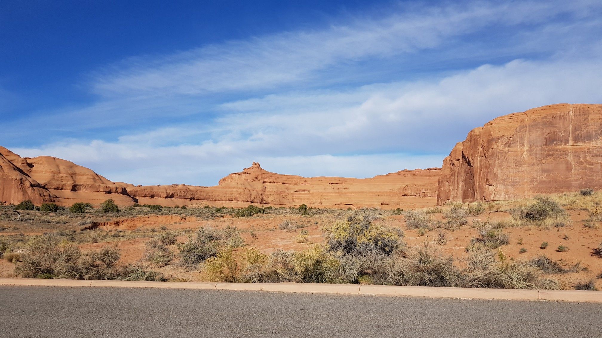 Expansive red rock formations rise above a desert landscape under a blue sky. - Courthouse Towers Viewpoint – Petrified Dunes Viewpoint loop from Petrified Dunes Viewpoint