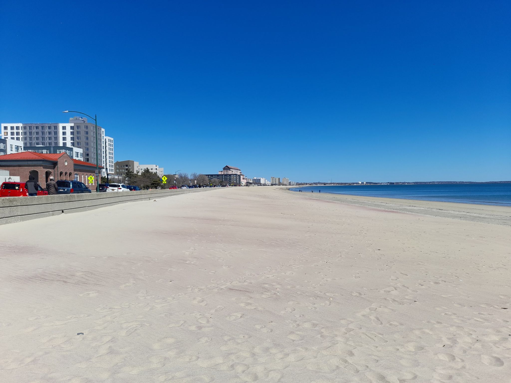 Wide sandy beach next to city buildings under a clear blue sky. - Revere Beach loop from Belle Isle Marsh Reservation