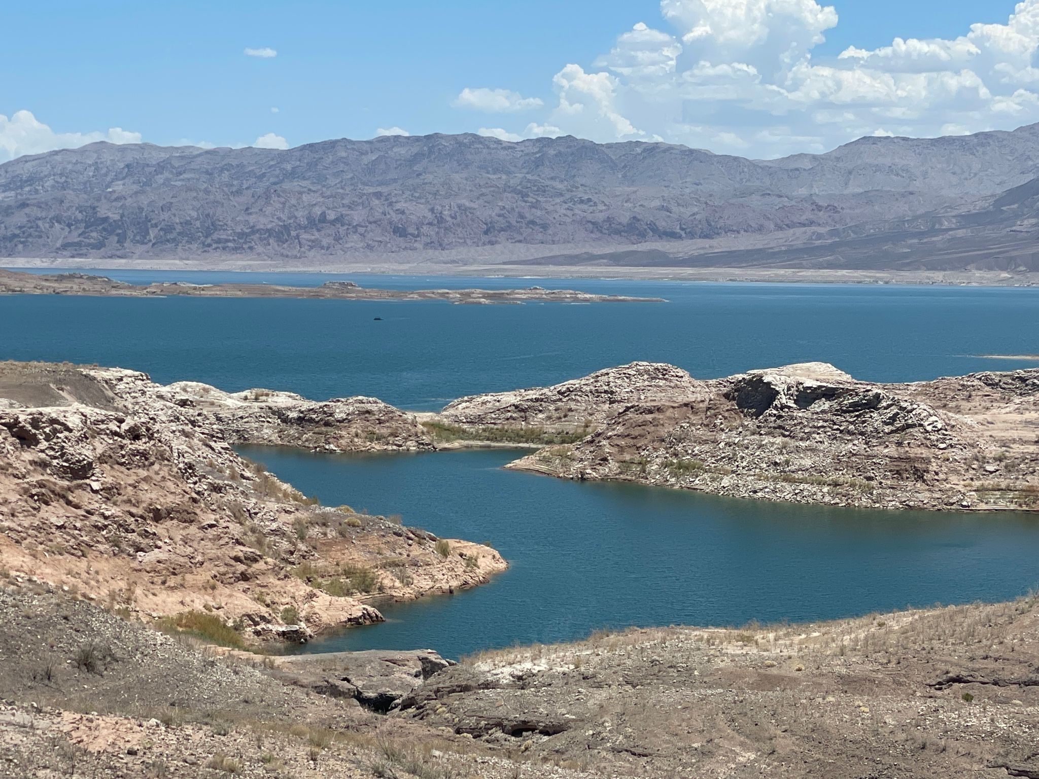 Vast blue lake surrounded by arid, rocky hills under a bright sky. - Sunset View Scenic Overlook Trail