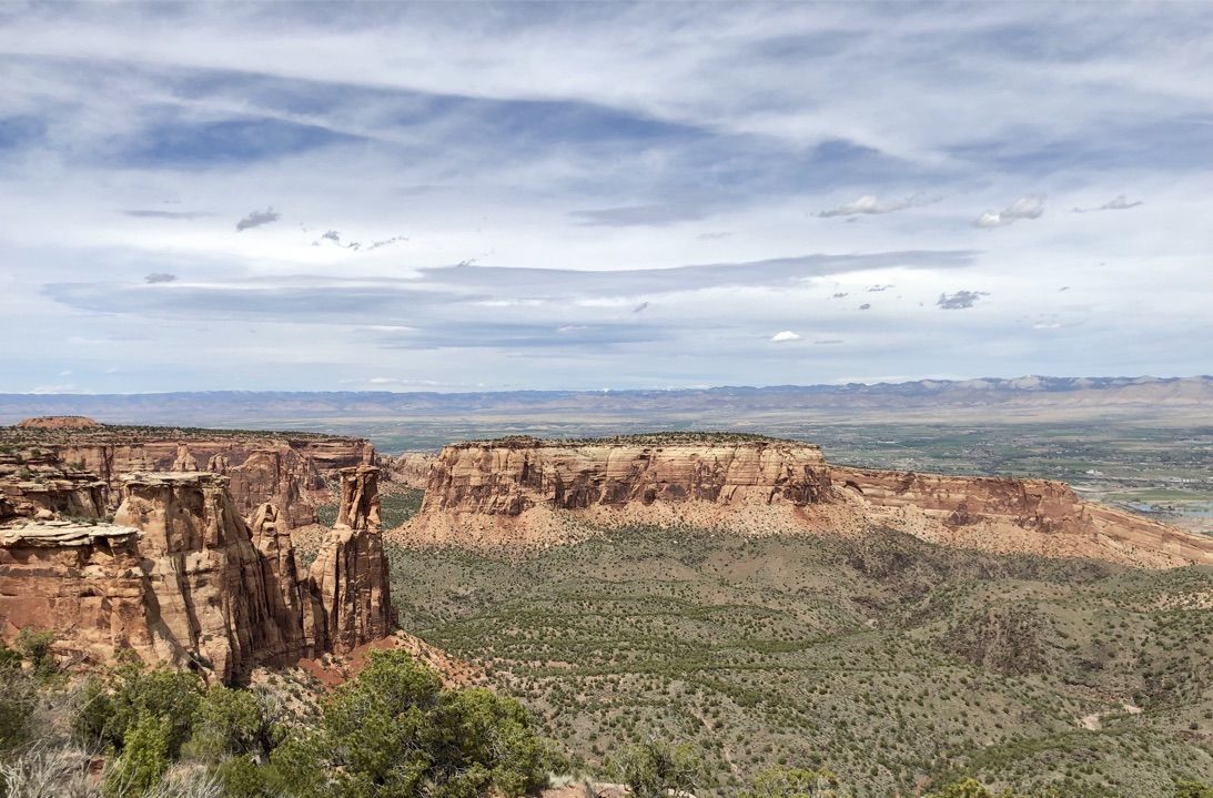 Panoramic canyon view with mesas, distant valley, and scattered clouds in the sky. - Coke Ovens Overlook – View of Balanced Rock loop from Fruita