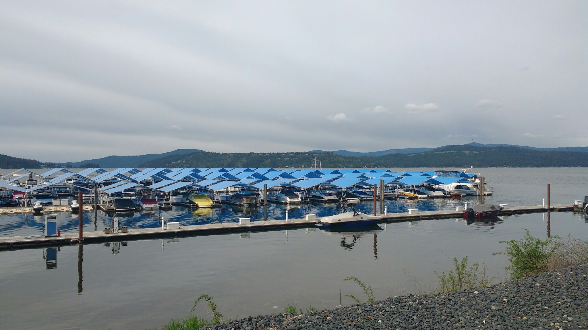 Large marina filled with many covered boats on a wide lake. - Silver Beach Marina loop from Coeur d'Alene