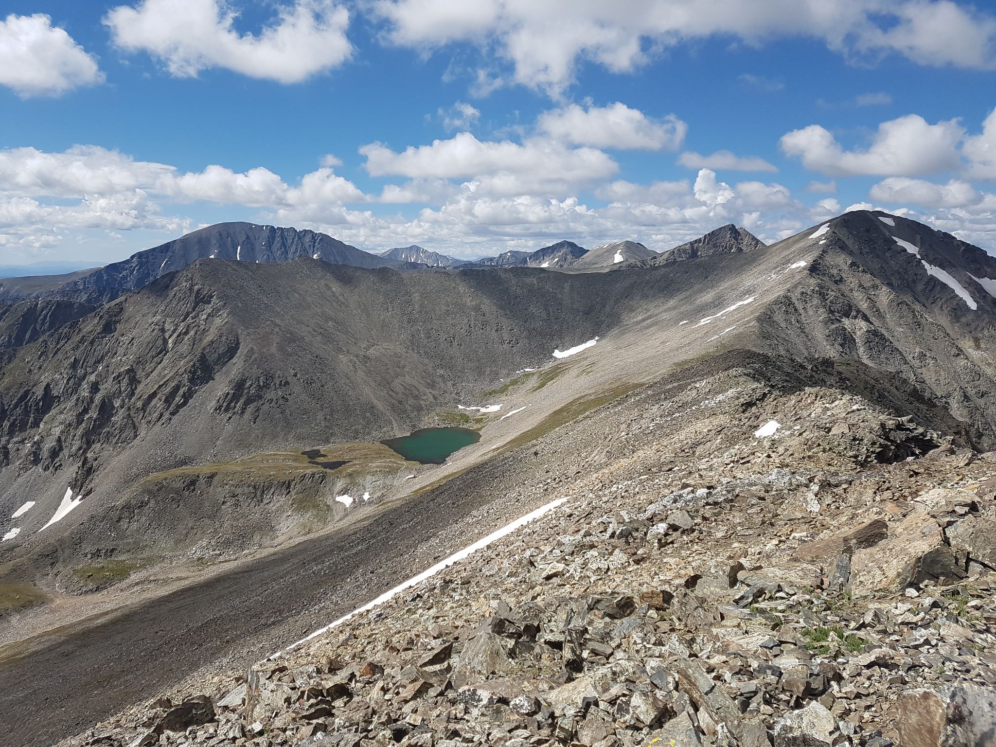Panoramic view of rocky mountain peaks, a green alpine lake, under a bright sky. - Ten Mile Peak to Peak (Tenmile Range Traverse)
