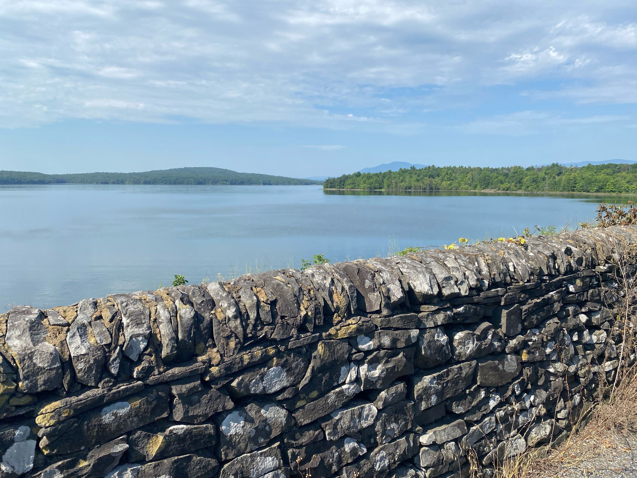 Stone wall in foreground overlooking a calm lake and distant forested hills. - Ashokan Rail Trail – Woodstock loop from Town of Woodstock