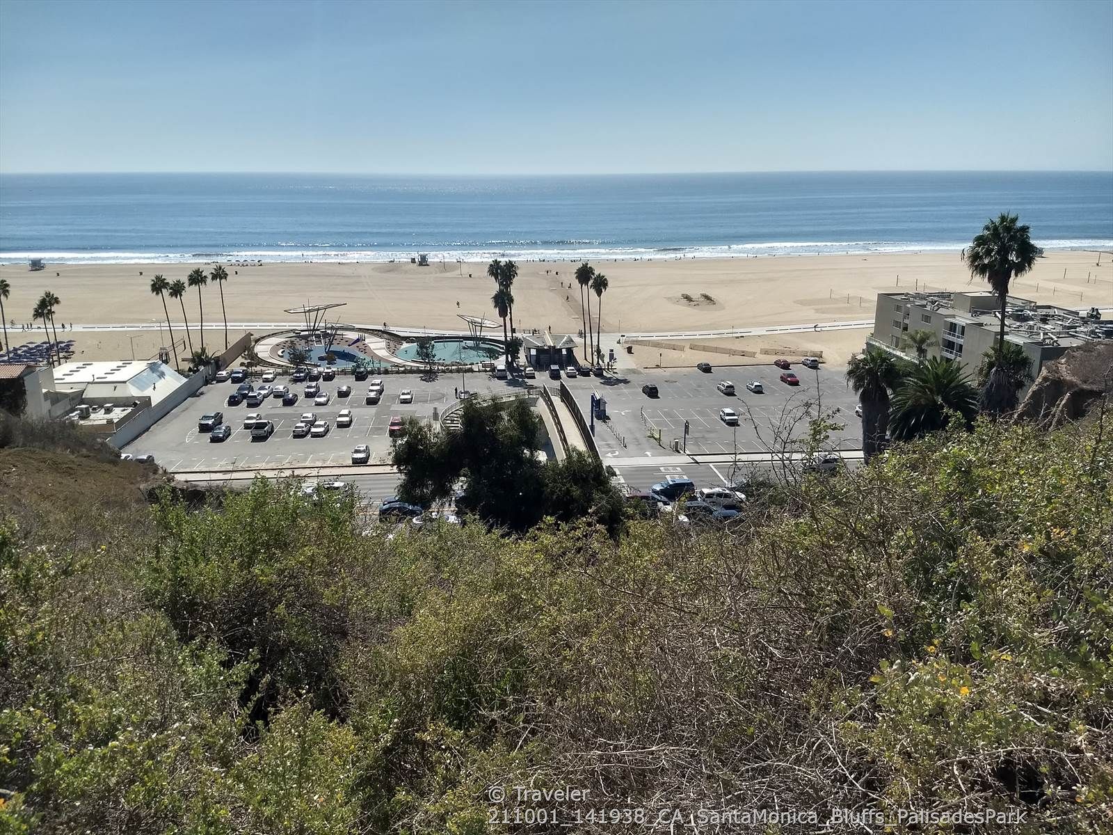 Aerial view of a sunny beach with ocean, parking lot, and buildings. - East Topanga Fire Road Loop