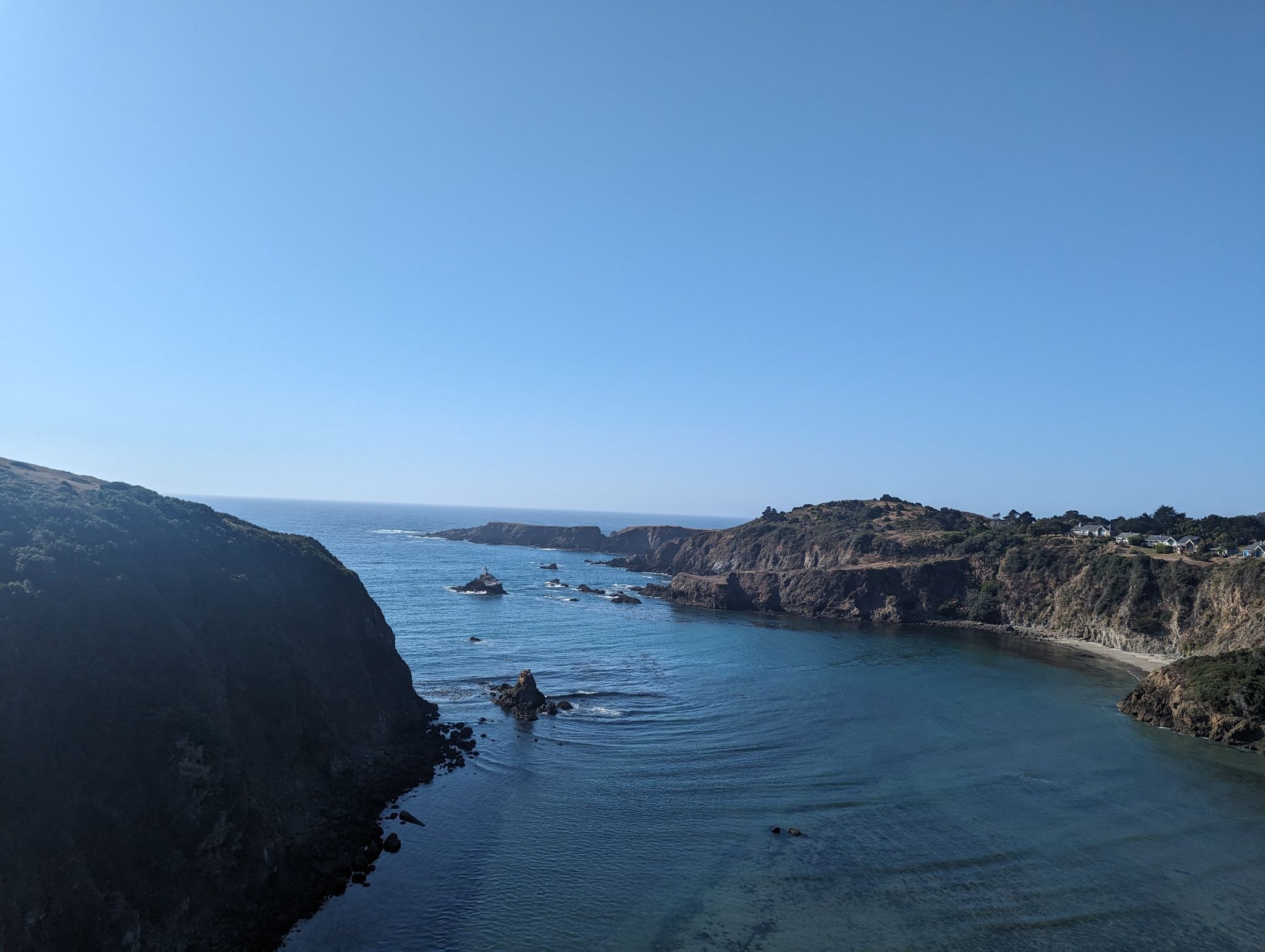 Expansive ocean bay with rocky outcrops and distant coastline under clear sky. - Albion River Bridge – Comtche loop from North Fork Navarro River
