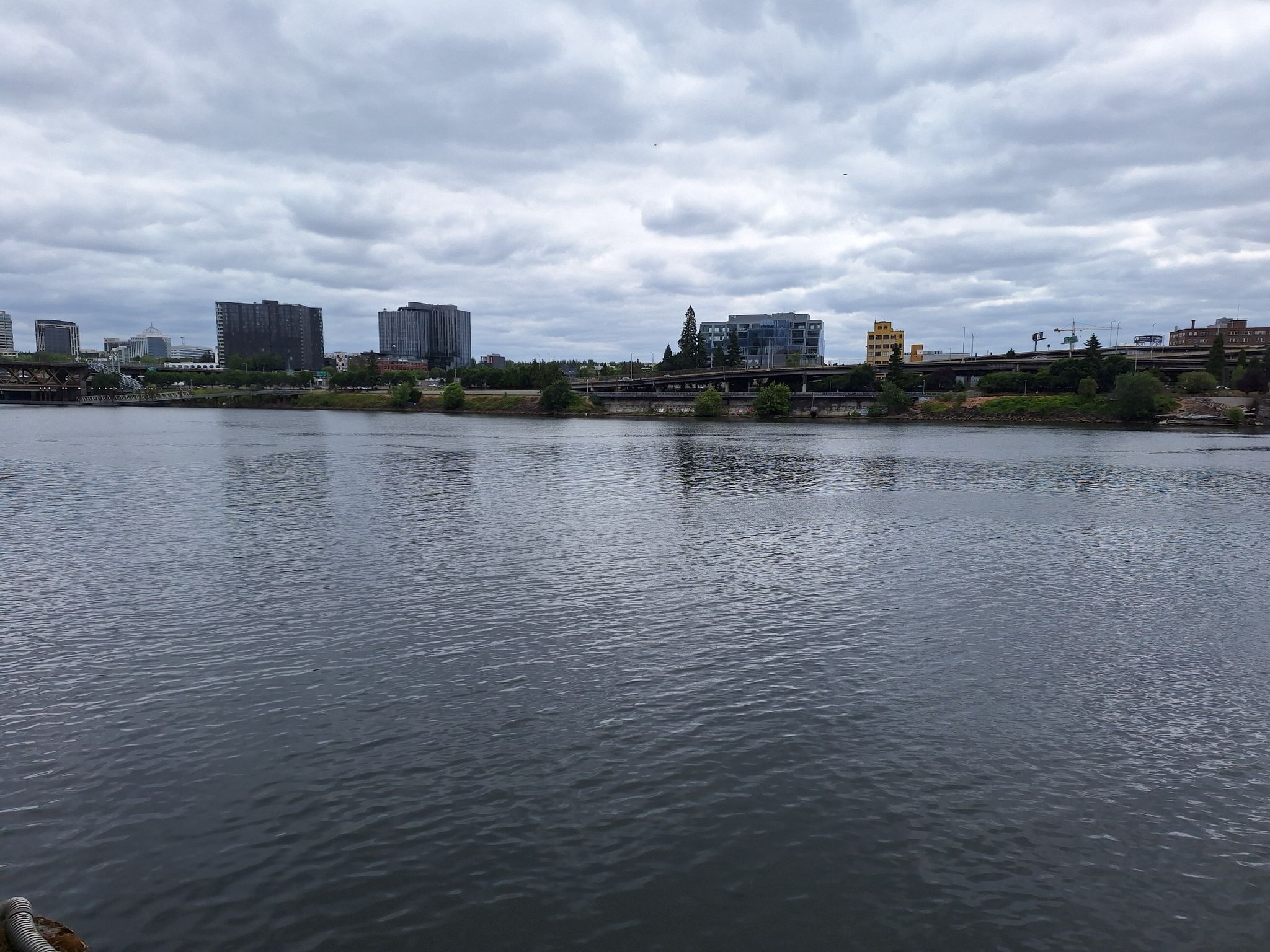 A wide river flows past a city skyline under a cloudy sky. - Leif Erikson Drive – Northwest Leif Erikson Drive loop from South Waterfront/South Moody