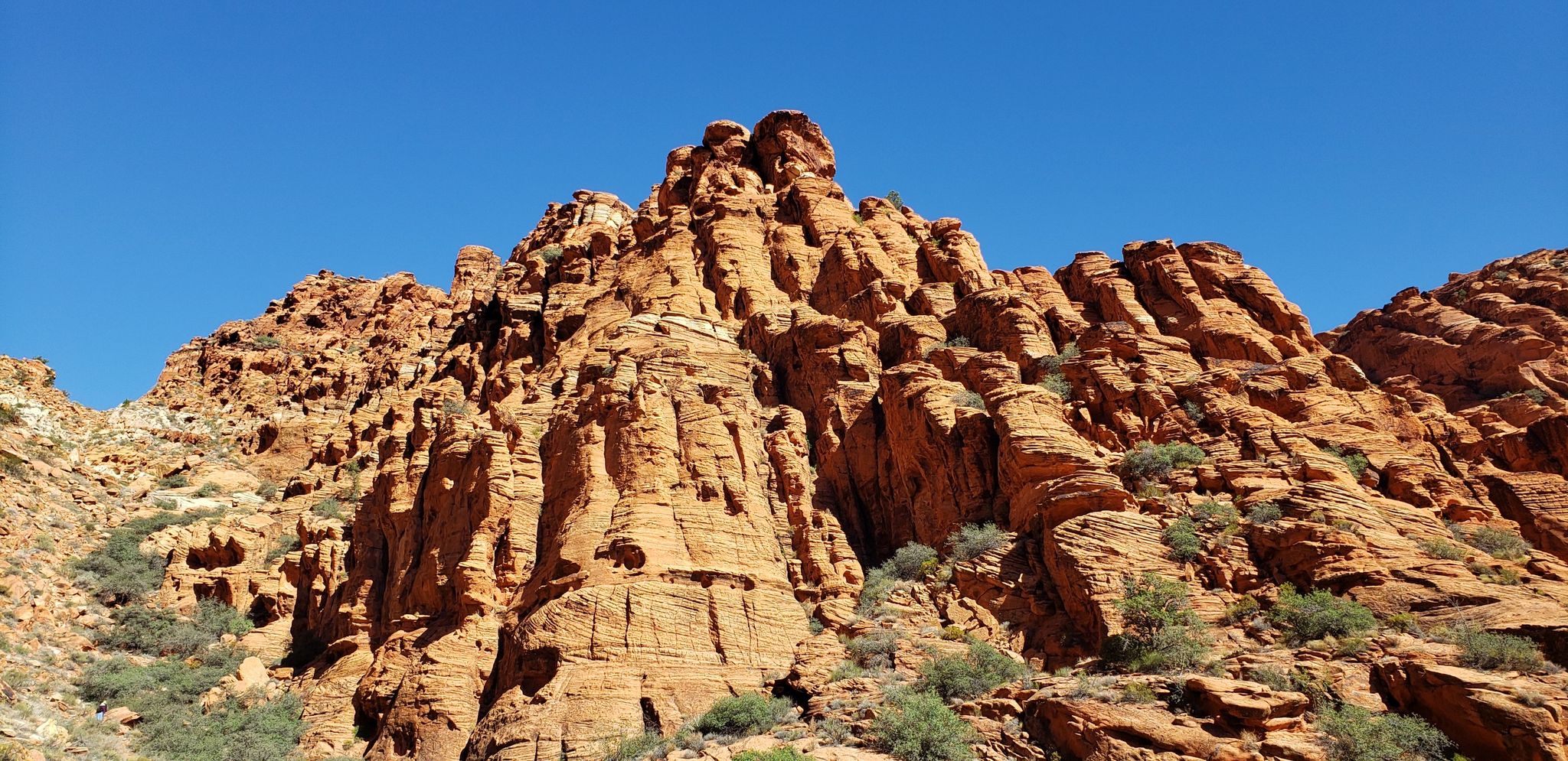 Towering, textured red rock formations against a bright blue sky. - Padre Canyon Trail