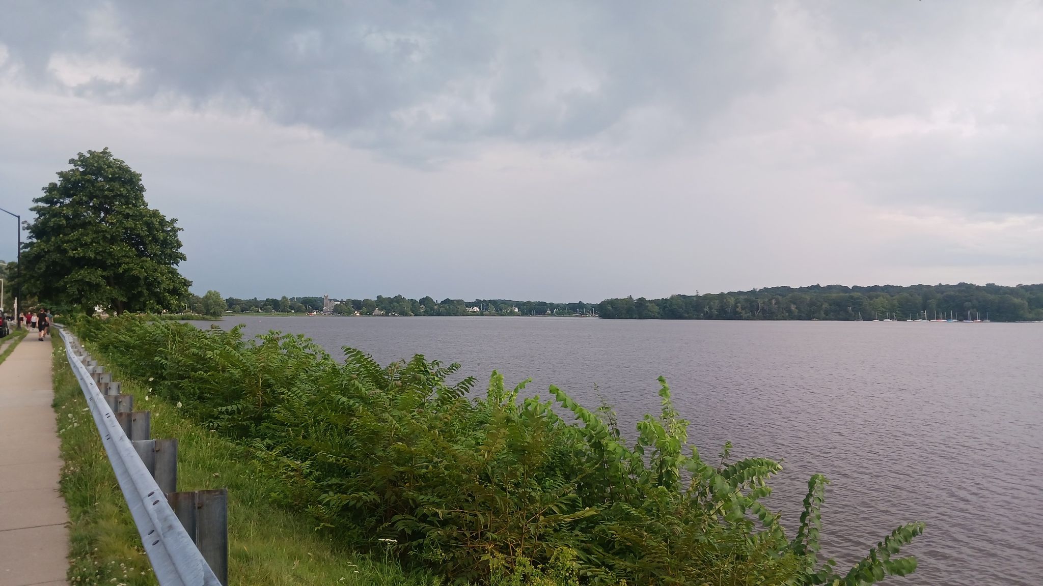 Overcast day with people walking beside a wide lake and distant trees. - Lake Quannapowitt – Lake Quannapowitt loop from Greenwood