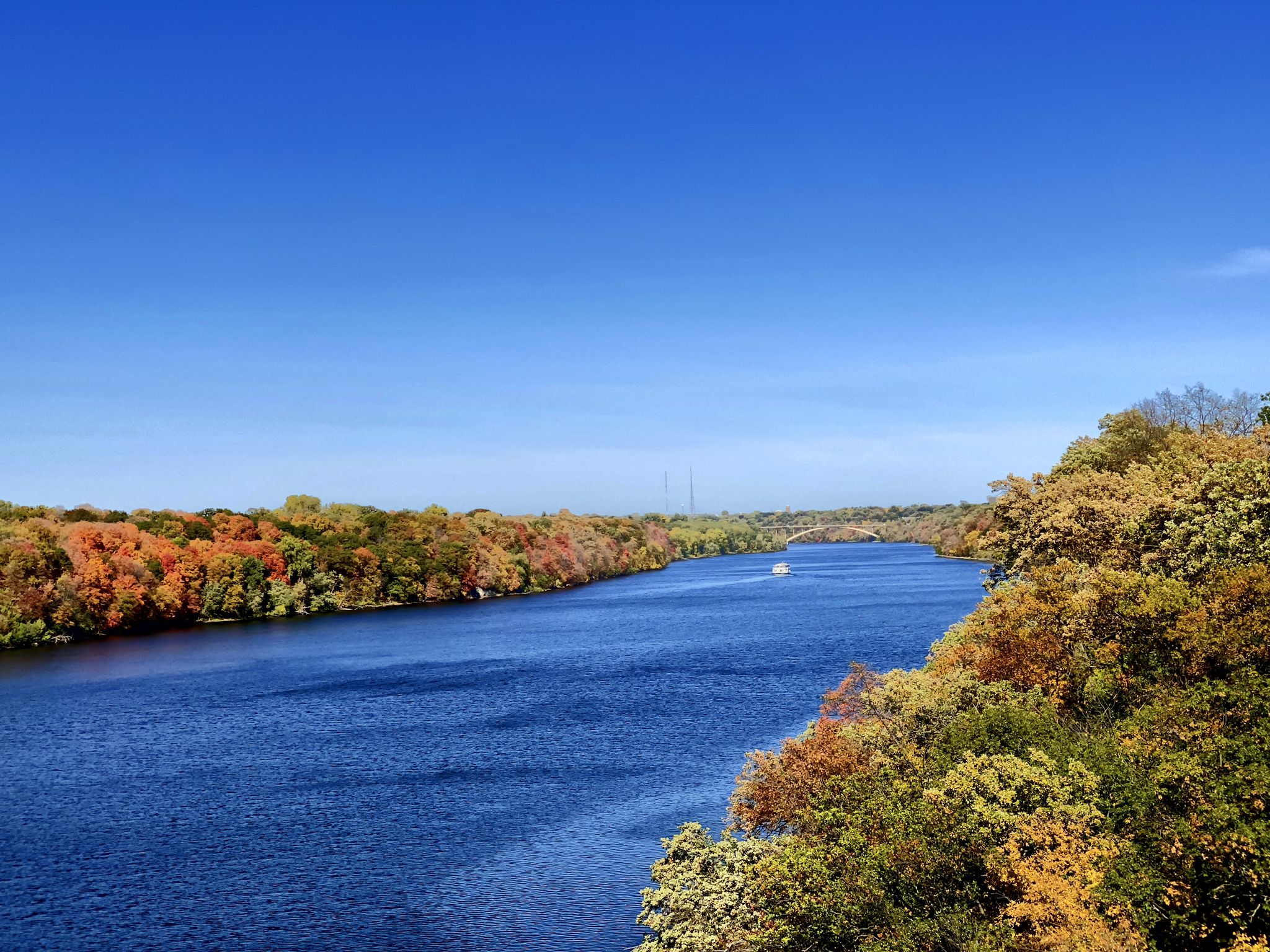 Wide river with colorful autumn trees under a clear blue sky. - East River Parkway – Mill Ruins Park loop from Minneapolis