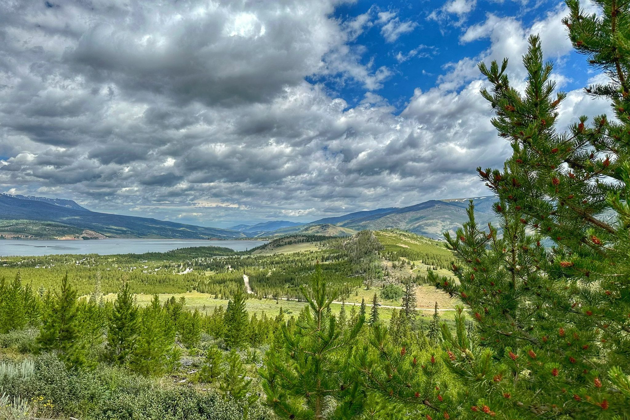 Expansive view of a lake, green hills, and distant mountains under a cloudy sky. - River Run – Swan Mountain Recreation Area loop from Keystone