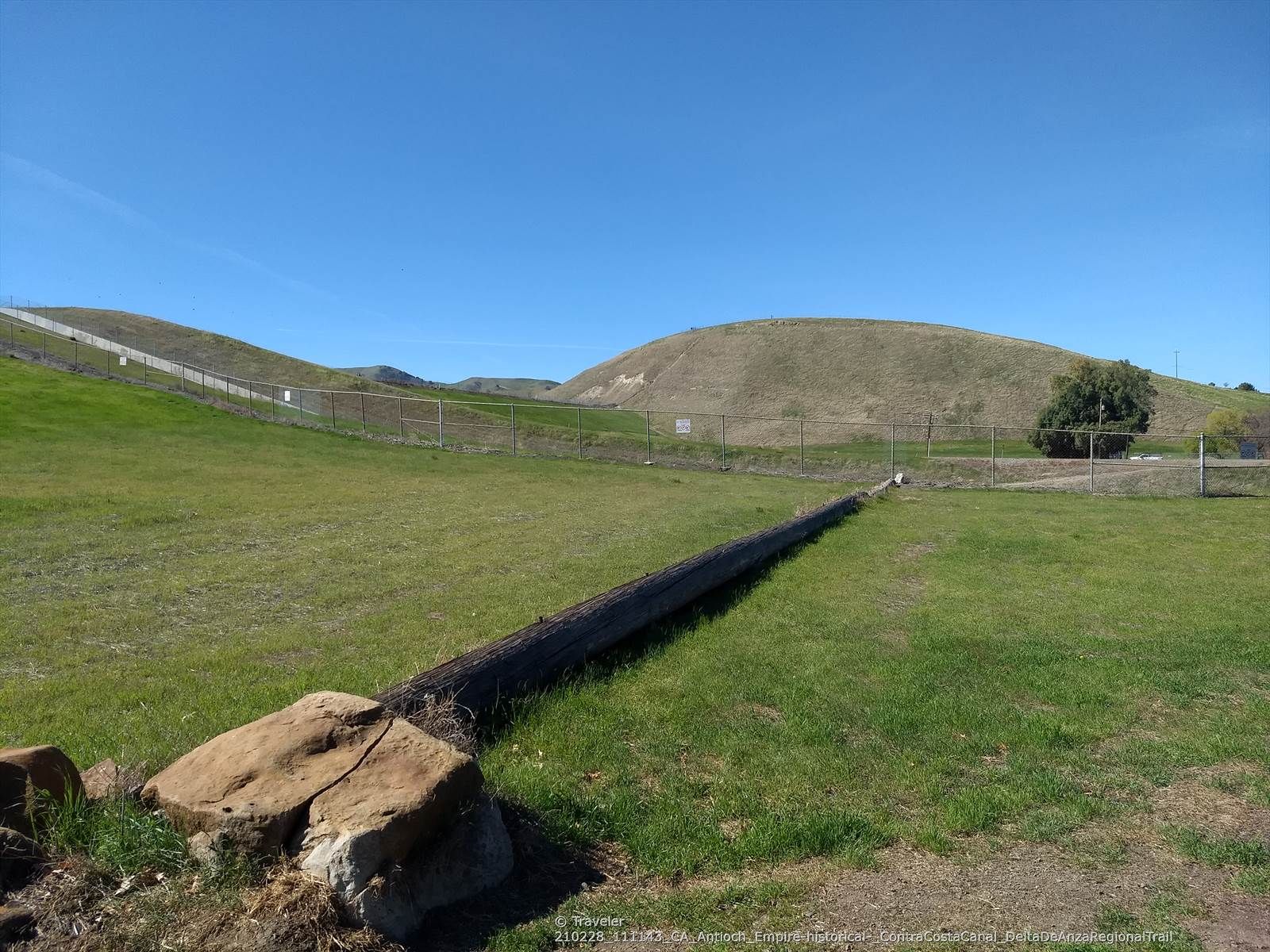 Green grassy field with a long pipe, rolling hills, and clear blue sky. - Roadbike loop from Balfour Road & McViking Way