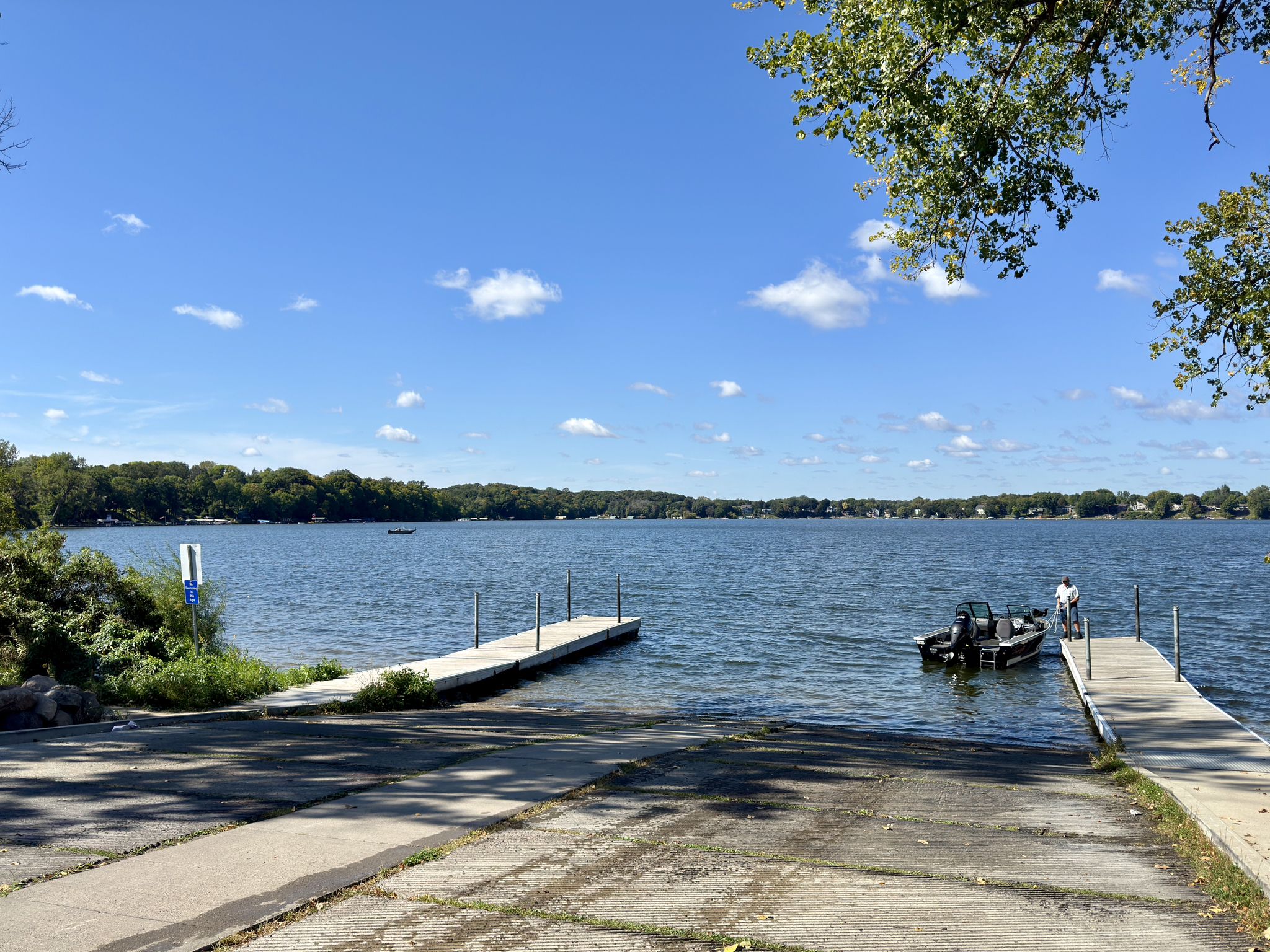 A boat launch with docks and a person near a boat on a sunny day. - Minnesota River Bluffs LRT Regional Trail