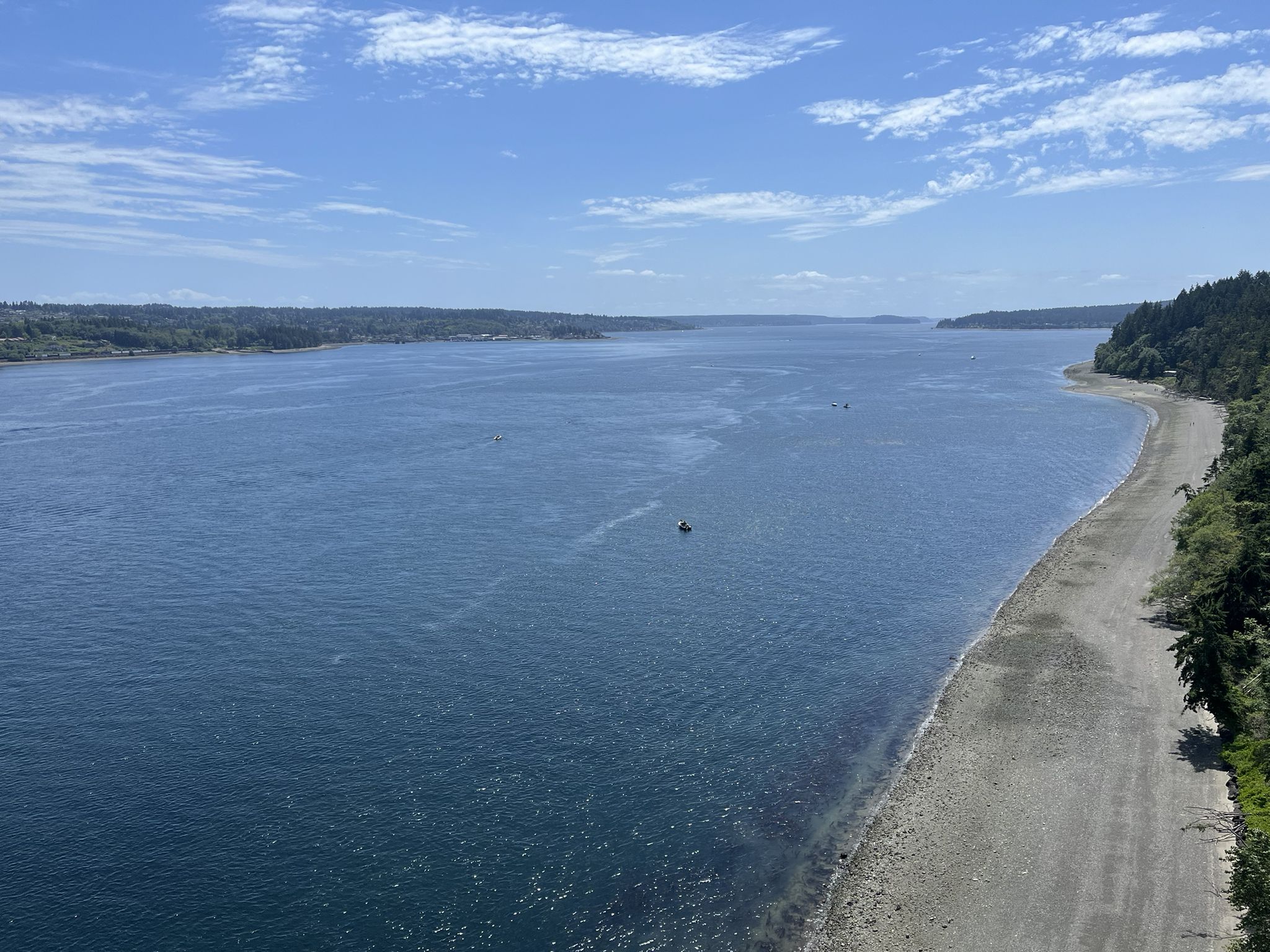 Wide blue water with forested shores under a bright sky, small boat. - Cushman Trail and Point Defiance Loop