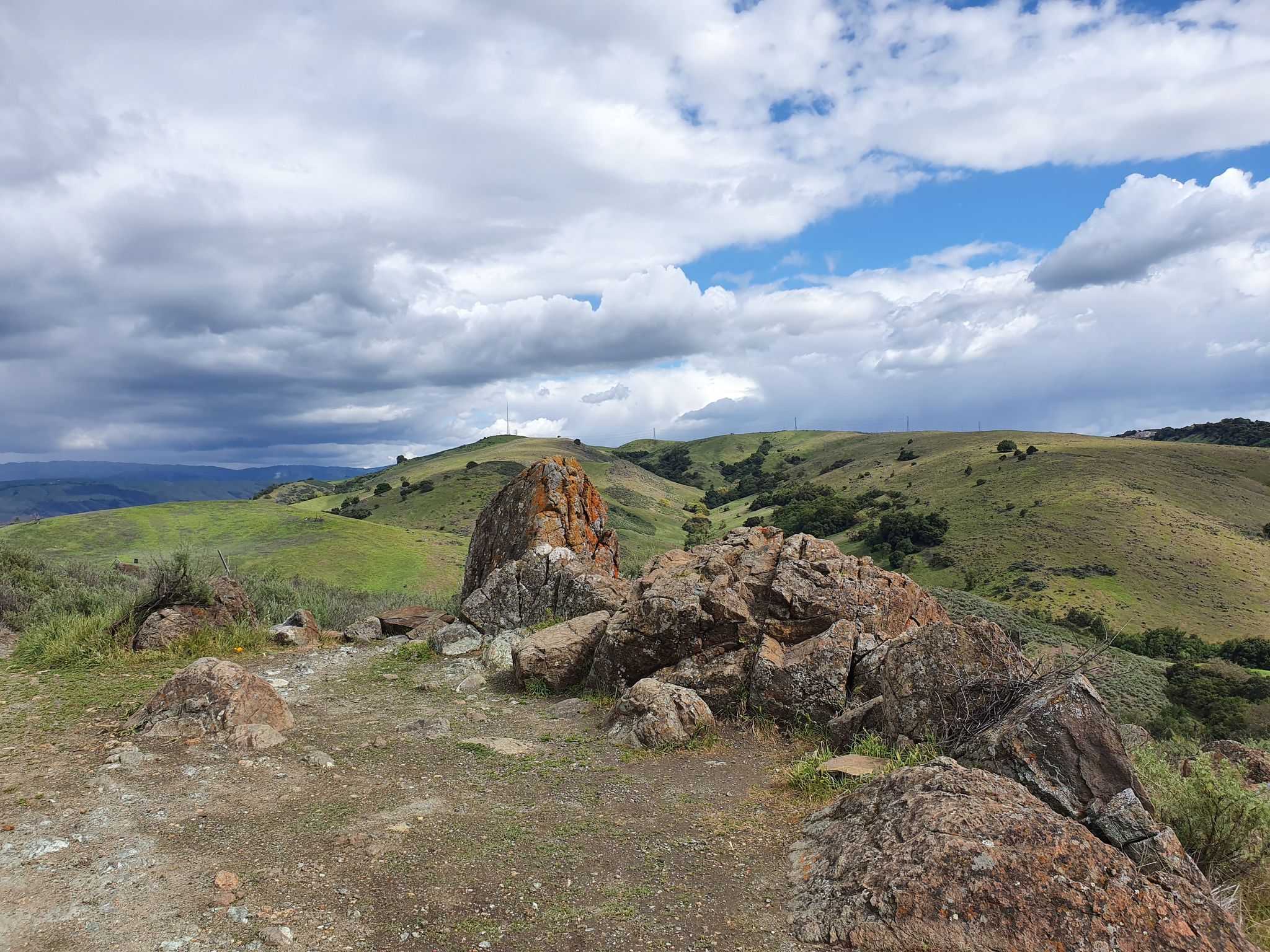 Large rock formation on a hill overlooking green valleys under cloudy sky. - Stile Ranch Trail loop from Rancho San Vicente Entrance