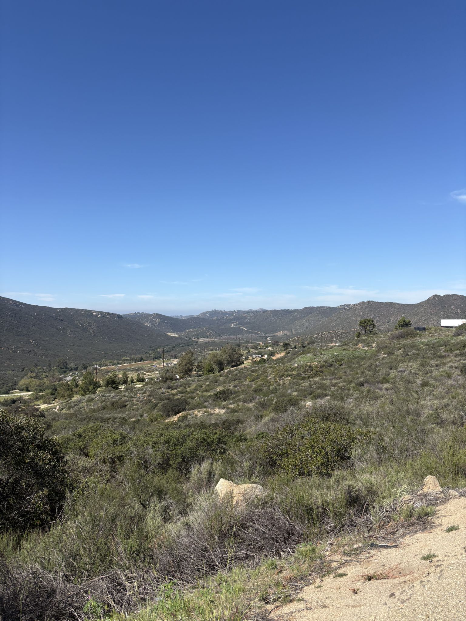 Wide view of rolling green hills and valleys under a bright blue sky. - Vista Point – Japutal Valey Road loop from Alpine