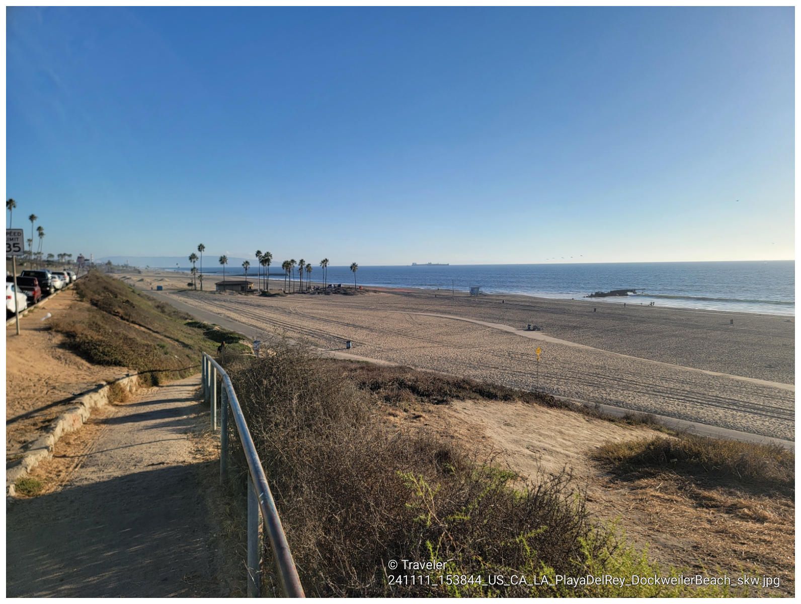 Wide sandy beach with ocean, palm trees, and a path under clear sky. - Ocean view loop from LAX/Metro Transit Center