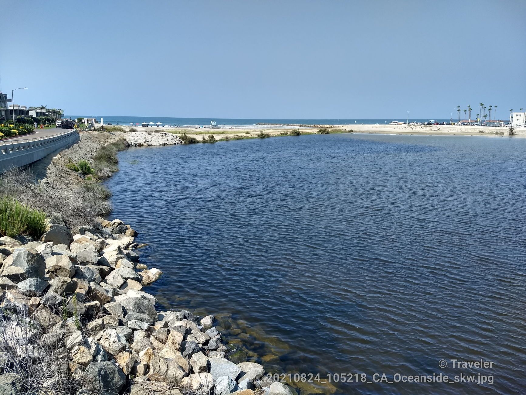 Calm water body with rocky shore, leading to a sandy beach and ocean. - Harbor Beach – San Luis Rey River loop from Oceanside