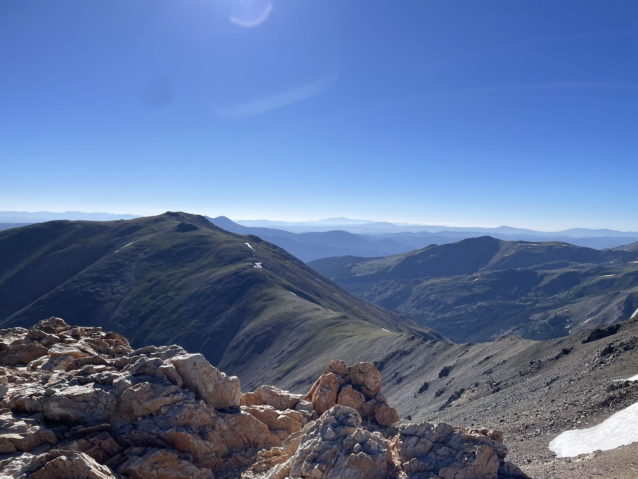 Sunny mountain range with rocky foreground and distant peaks under a clear blue sky. - Mount Belford via Missouri Gulch Trail