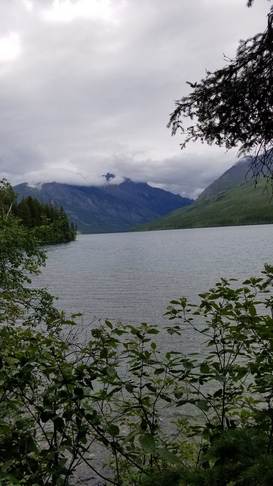 Overcast day over a large lake with cloud-covered mountains in background. - Kintla Lake Head