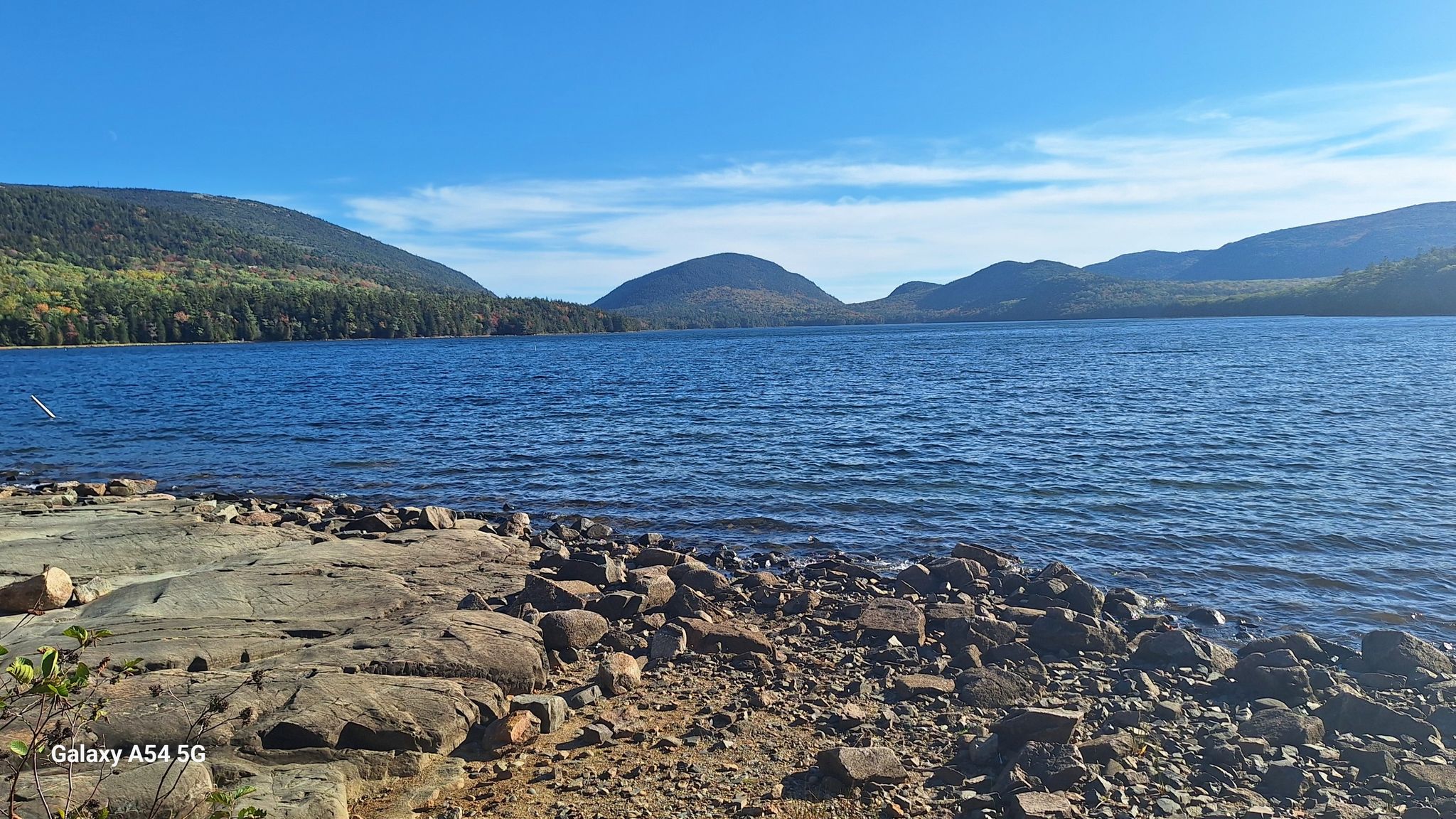 Wide lake with rocky shore, distant forested mountains, and clear blue sky. - Duck Brook Falls – Eagle Lake loop from Bar Harbor