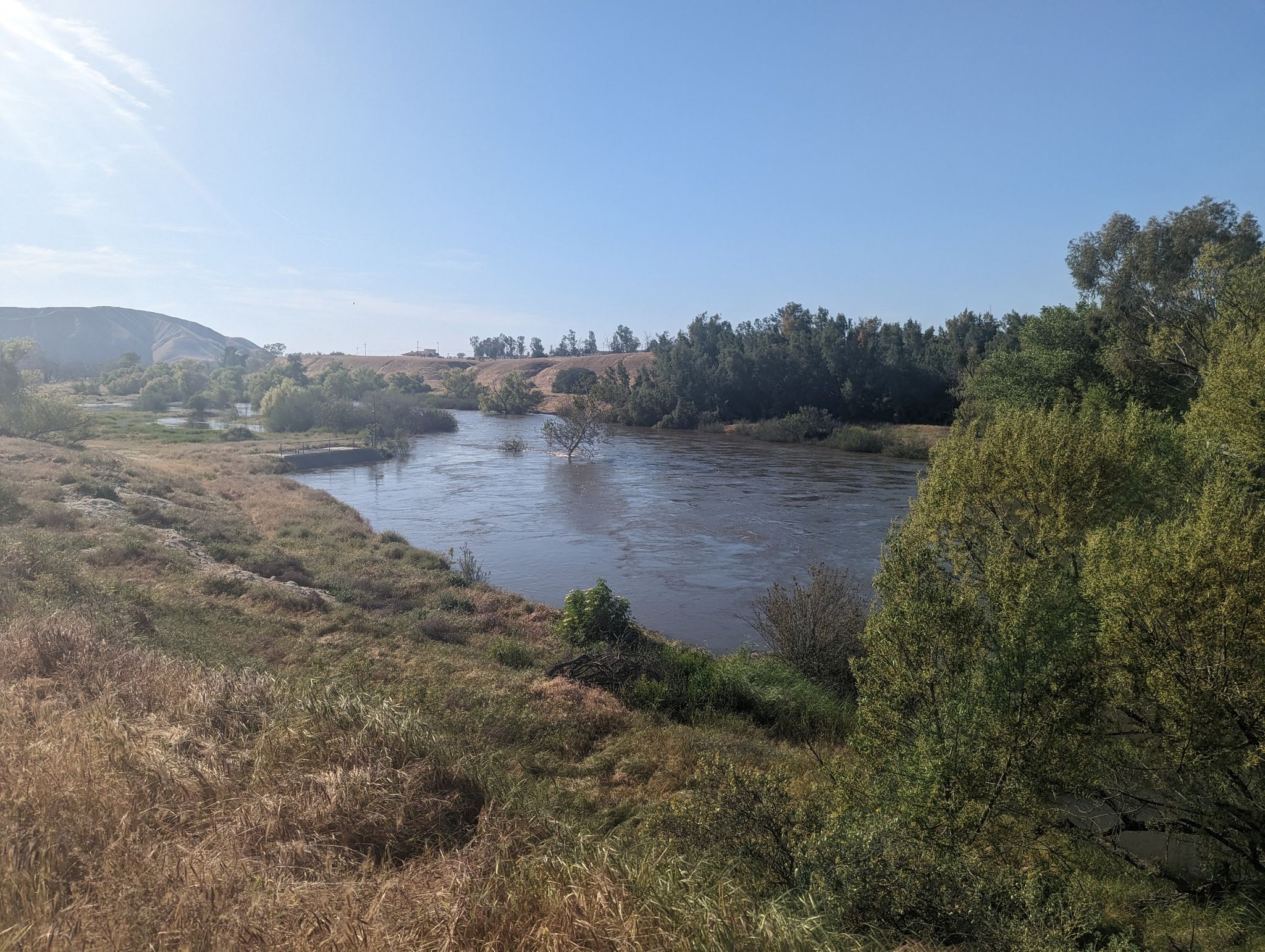 A winding river with dry grassy banks and green trees under bright sun. - Mushroom Meadow – Luna Lake loop from Lake Ming County Park