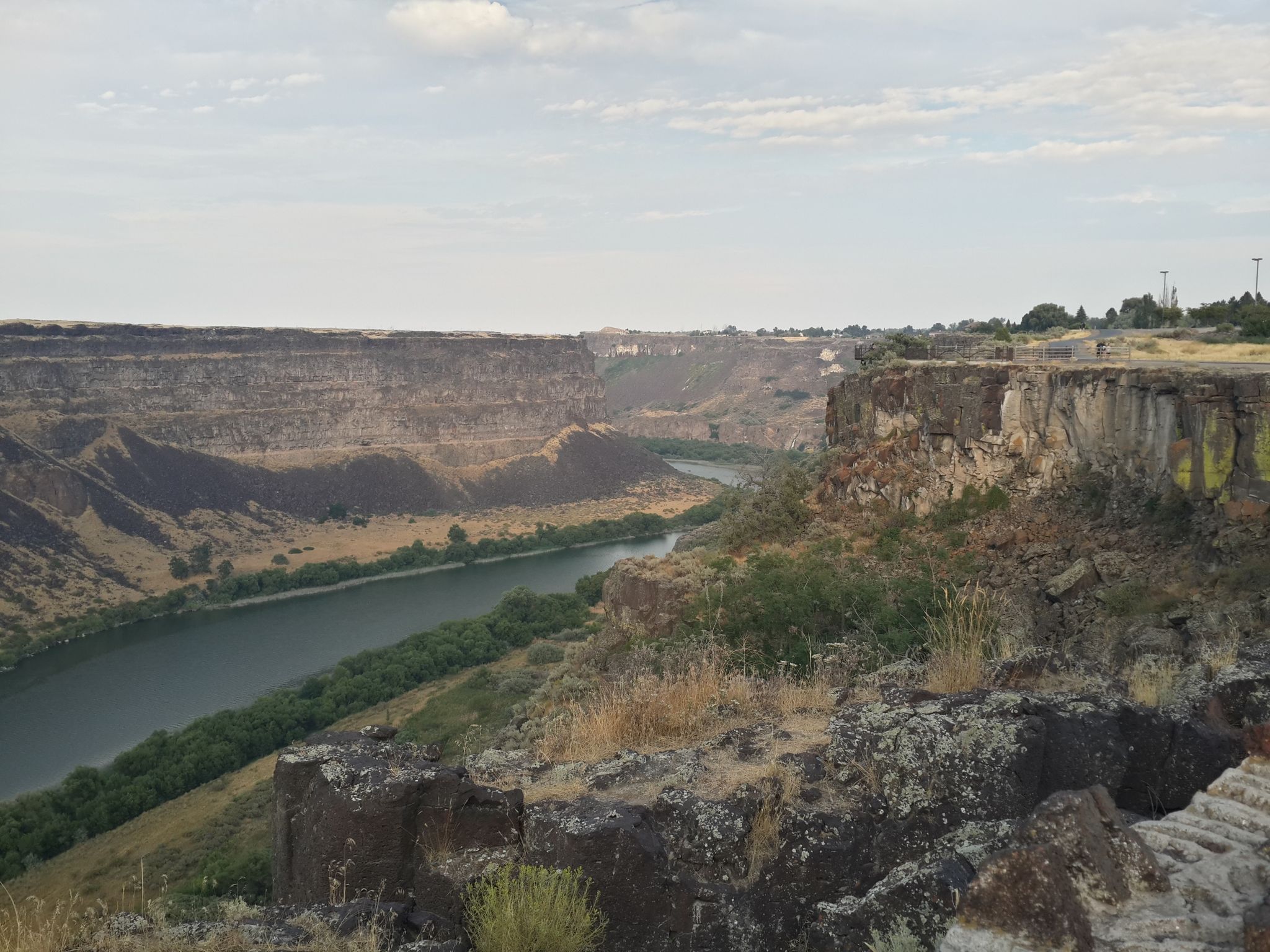 River winding through a deep canyon under a cloudy sky. - Canyon Rim Trail