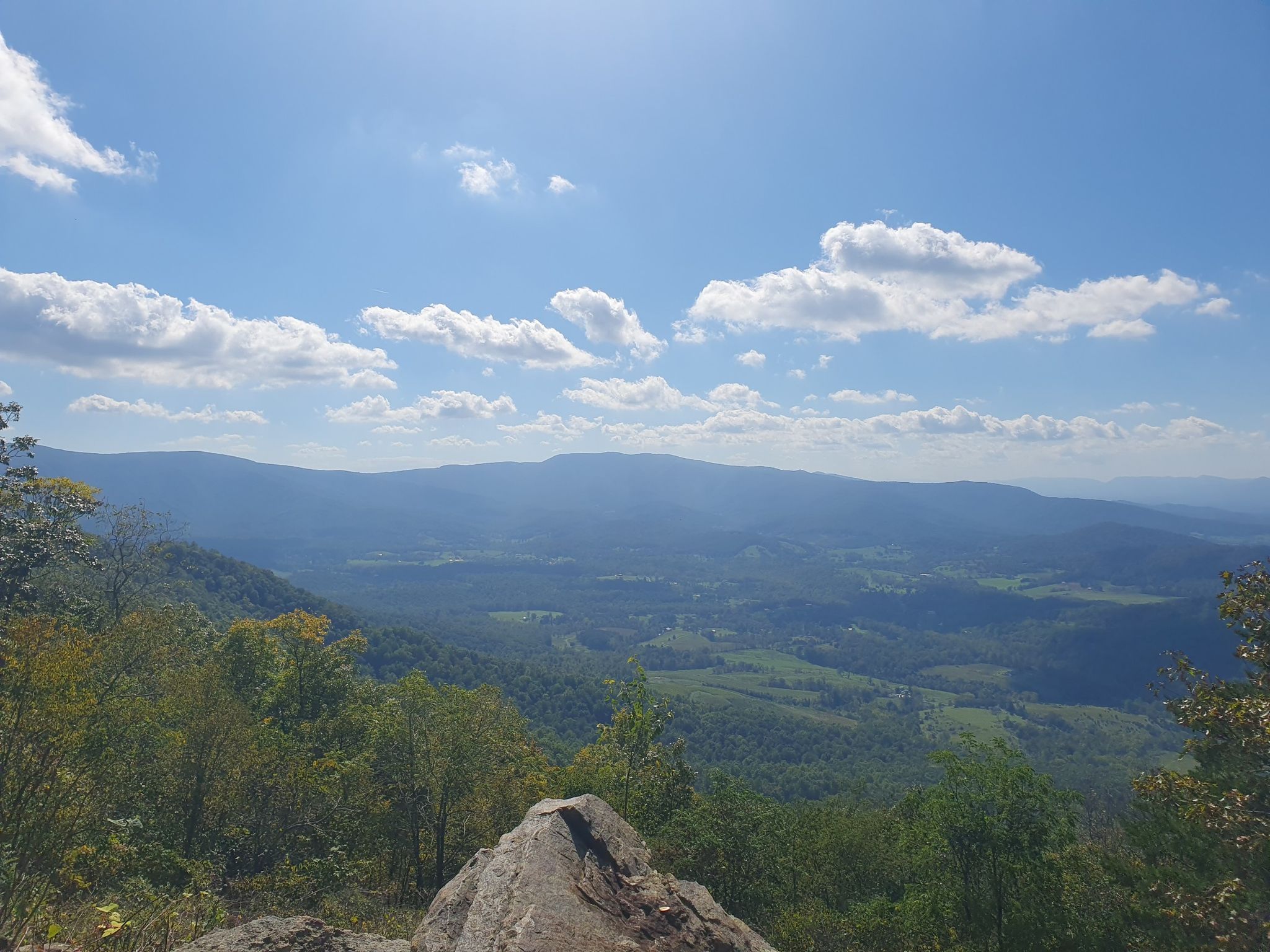 Sunny mountain vista with a valley below, partly cloudy blue sky. - Dickey Ridge Visitor Center – Carson Mountain loop from Front Royal