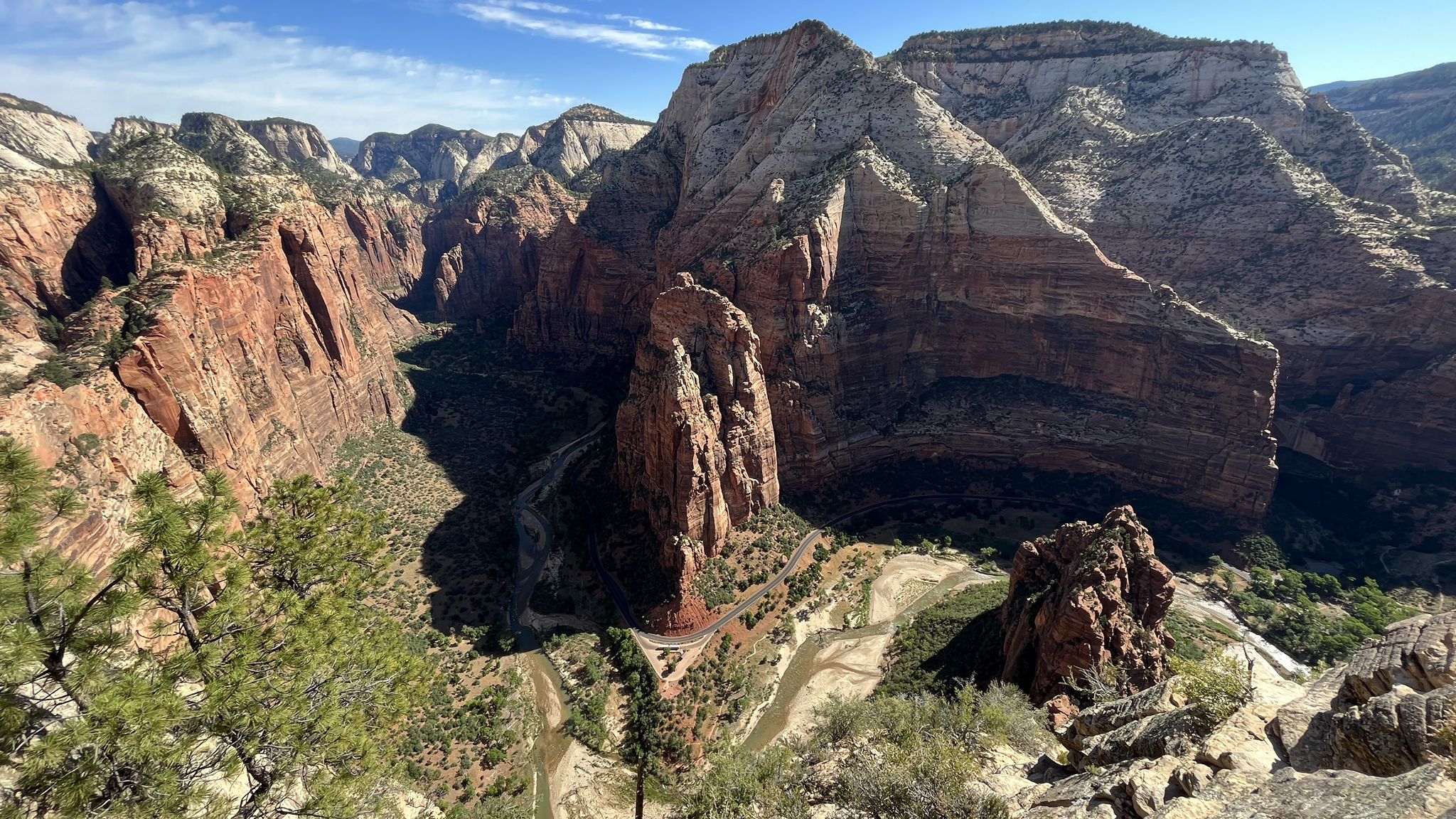 Expansive canyon vista with towering rock formations, a winding river, and clear skies. - Zion National Park Scenic Drive