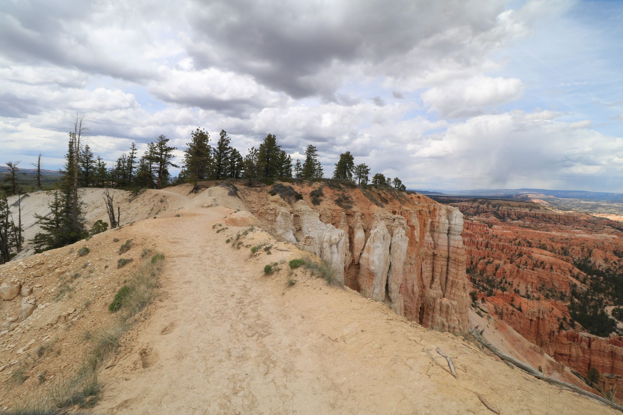 Dirt path on a ridge overlooking a vast canyon with red rock formations. - Lower Inspiration Point – Liberty Castle loop from Bryce Canyon Lodge