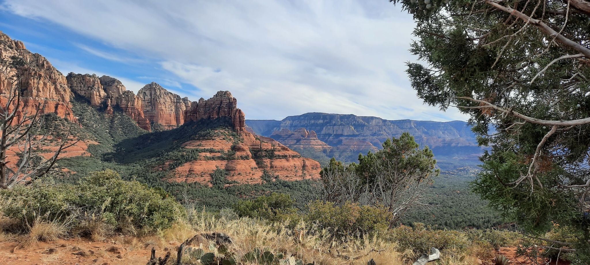 Red rock formations and green valley under a partly cloudy sky. - Soldier Pass & Brins Mesa loop – Red Rock-Secret Mountain Wilderness