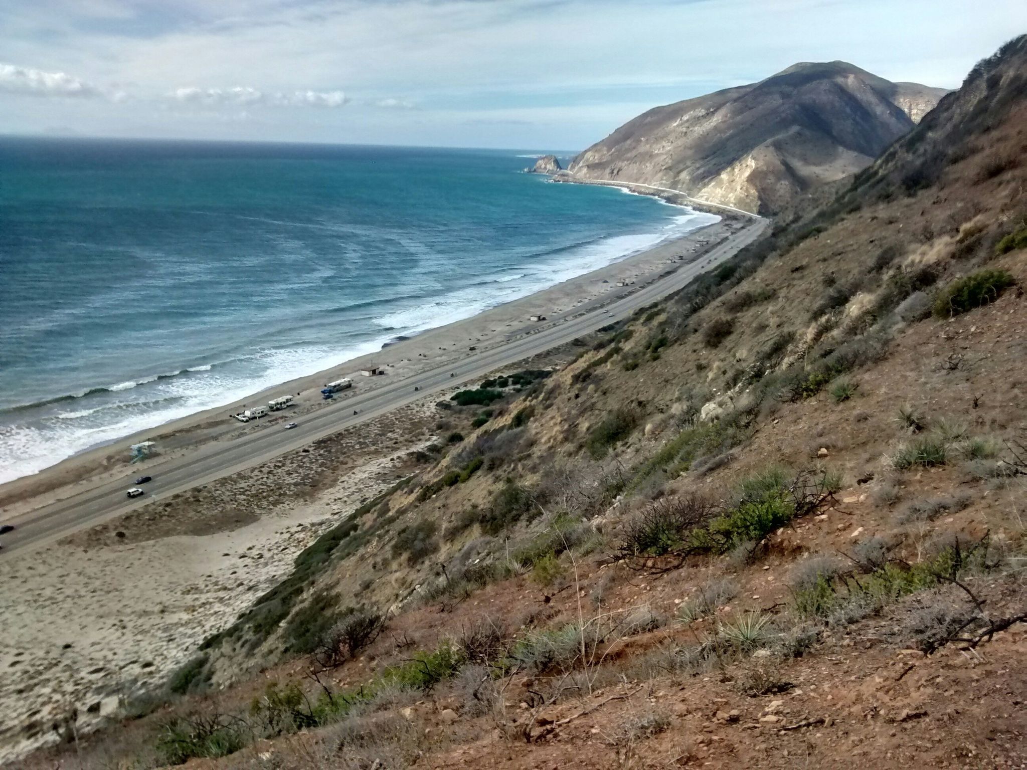 Bright view of a coastal highway beside a sandy beach and ocean. - Ray Miller and Overlook Trail Loop