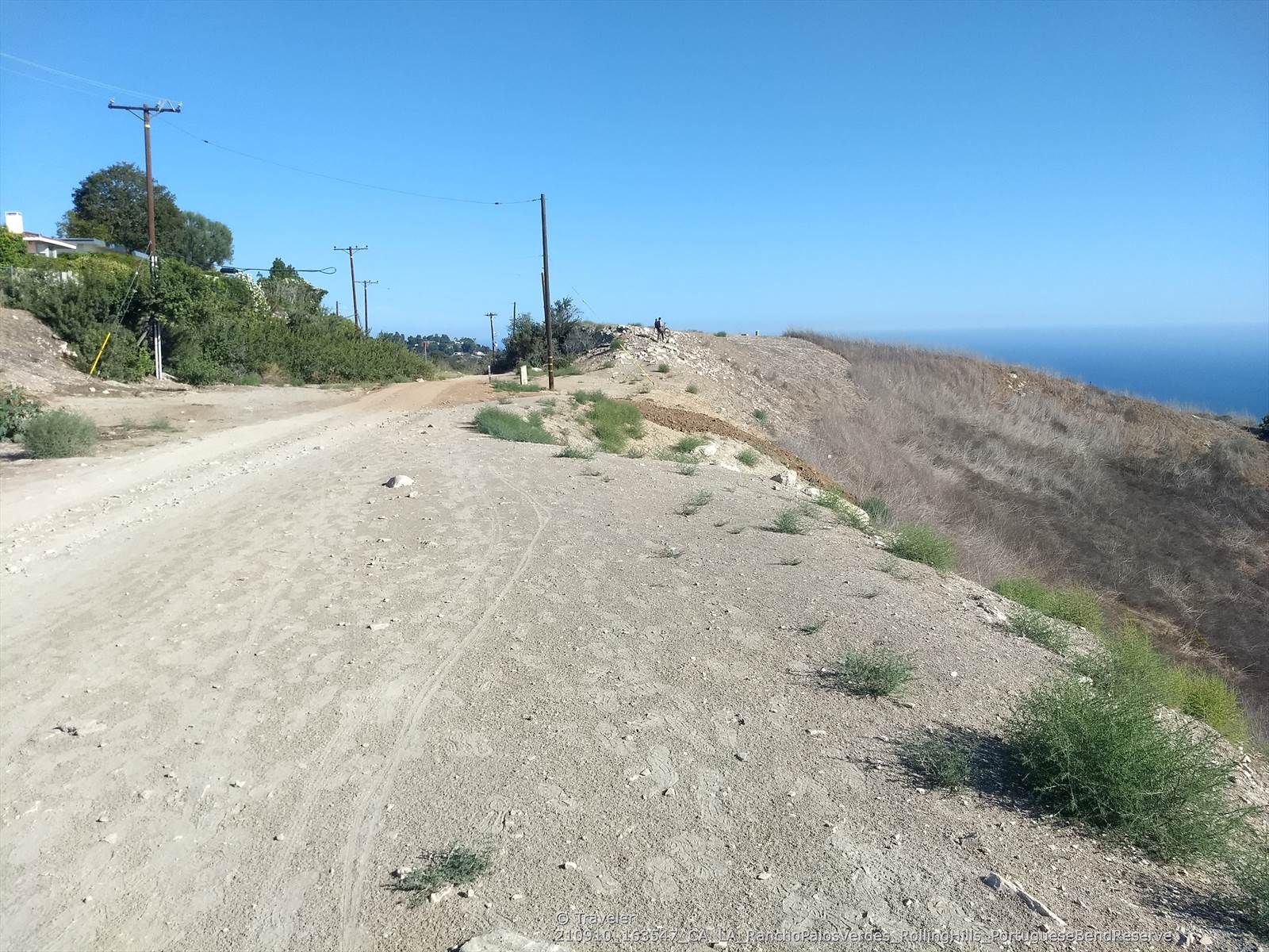 Wide dirt road on a ridge, with power lines and ocean in distance. - Bluff Cove – Torrance Beach loop from Torrance